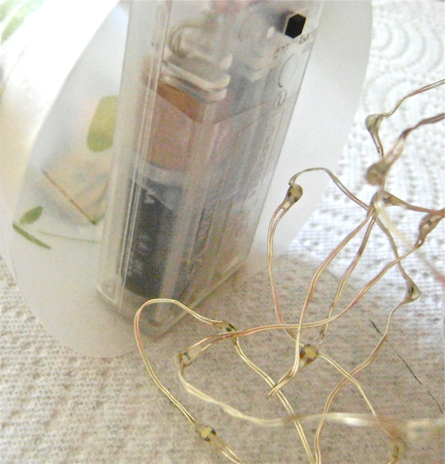 step 10 - Hot glue one end of the battery pack to the joined bottom edge inside the shade, and the other end of the battery pack to the inside front. The battery pack will anchor the shade and give it stability. 