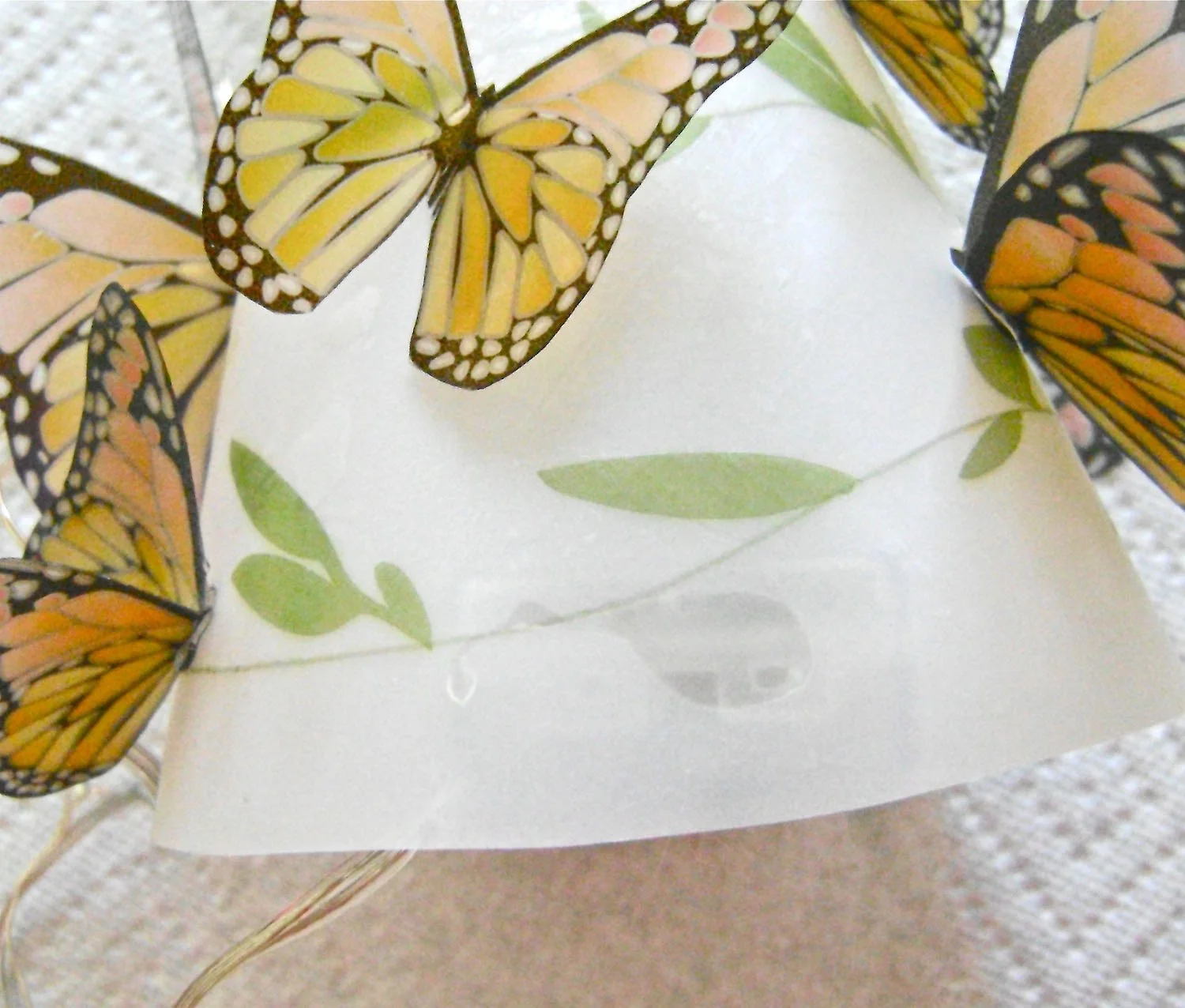 step 11 - To hide the spot where you hot glued the shade to the battery pack, attach a small butterfly. Stuff the lights inside the shade and enjoy your lamp!