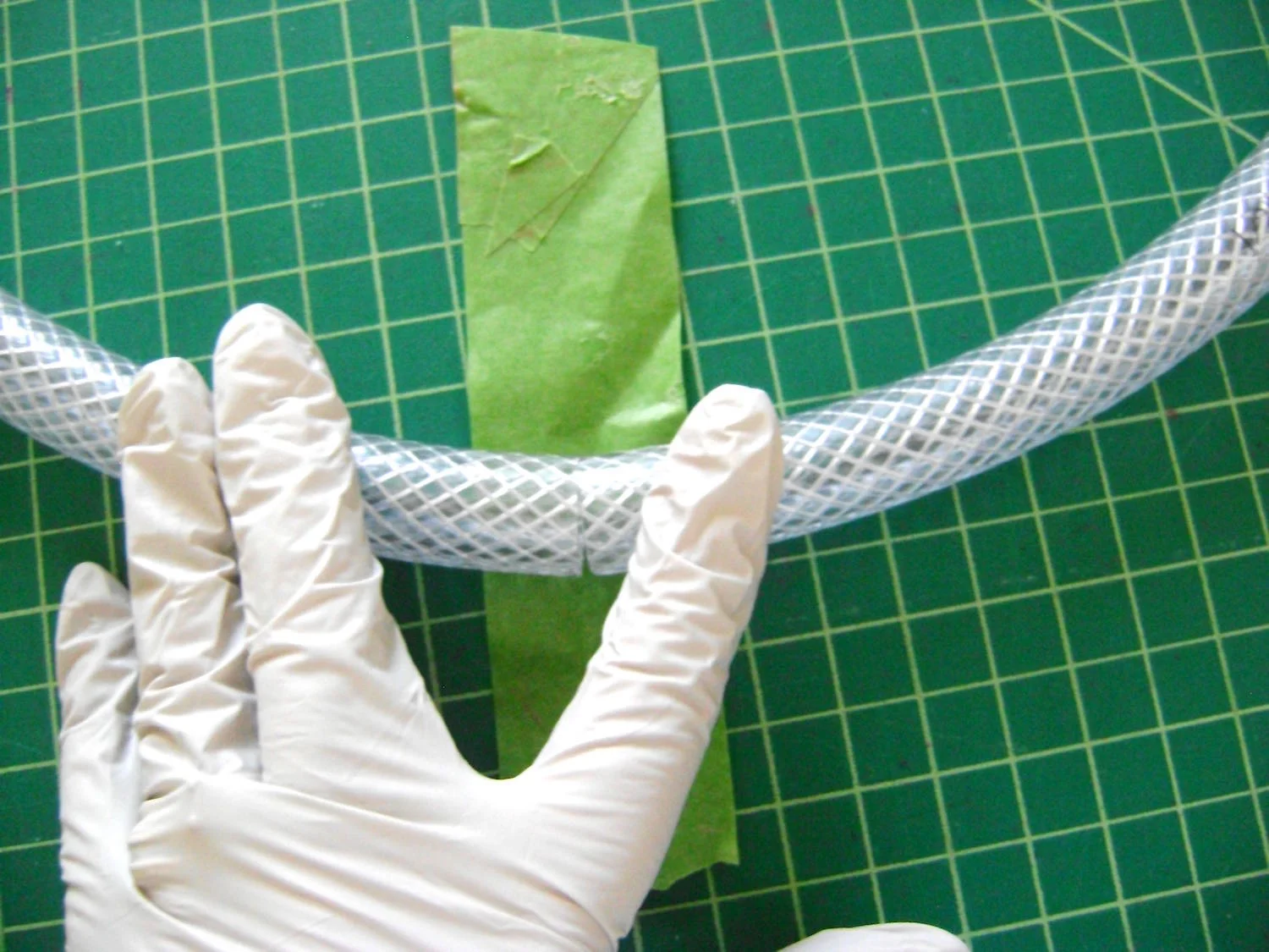 step 1 - Cut hose to measure 36” long. Bring the ends together and tape them with frog tape to form a perfect 12" circle.