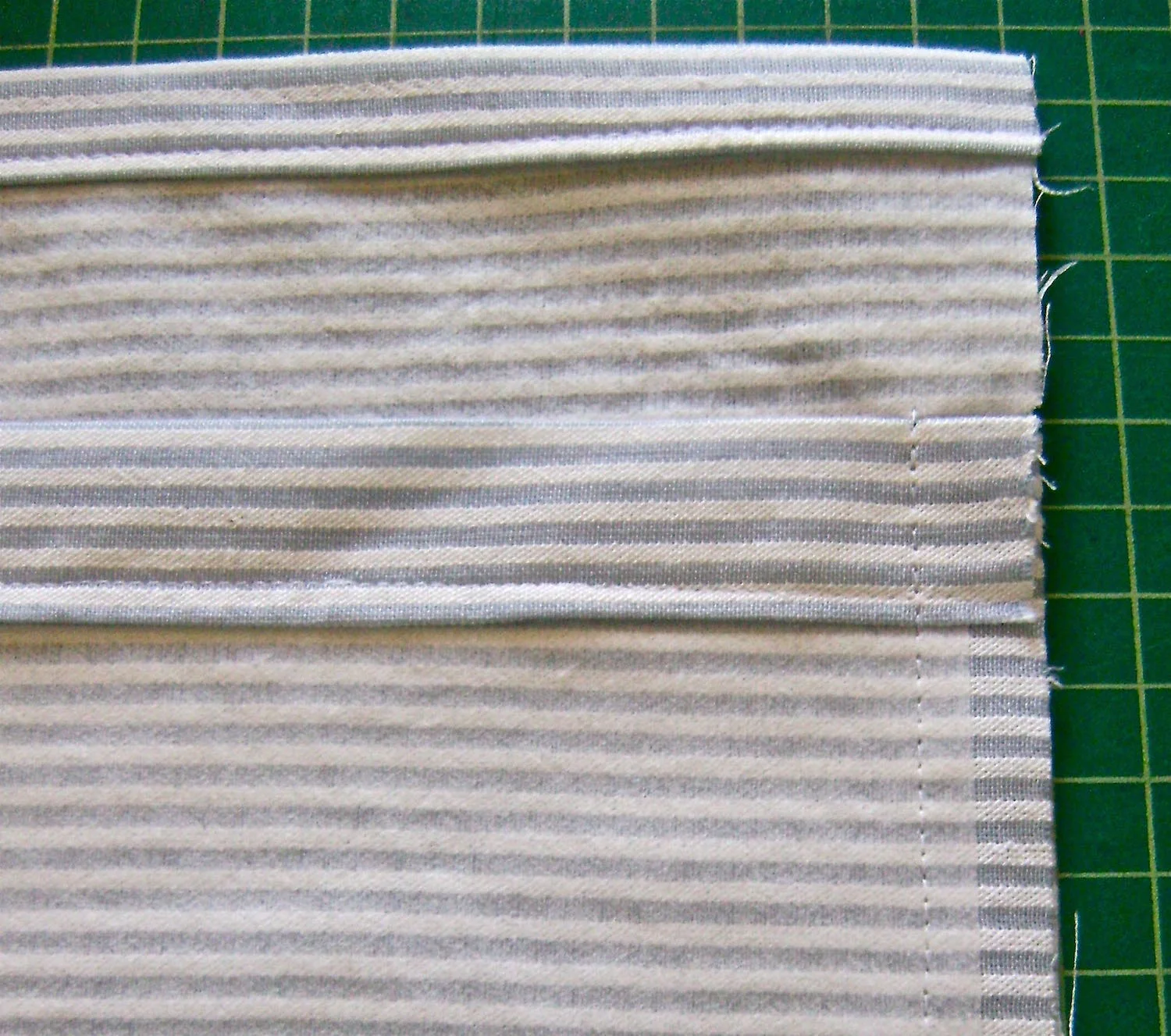 step 10 - With the right side of the pocket to the wrong side of the pocket back, sew the bottoms together. Press the seam allowance toward the pocket back. Trim the allowance to a quarter of an inch. Sew the side seams.