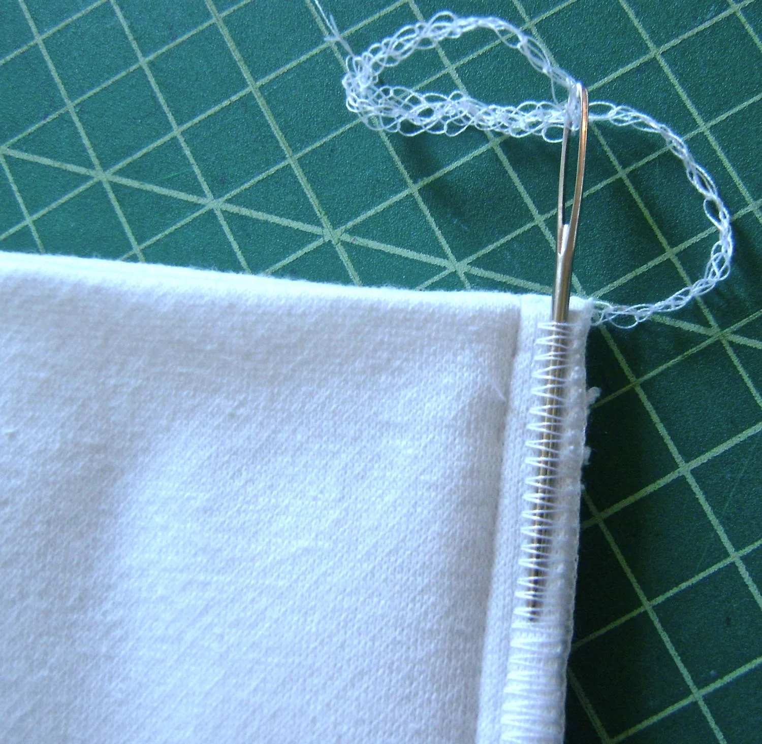 step 7 - If you serge the sides, leave a long tail of thread. Put it into a large darning needle and bring it back through the serged stitches to secure them.