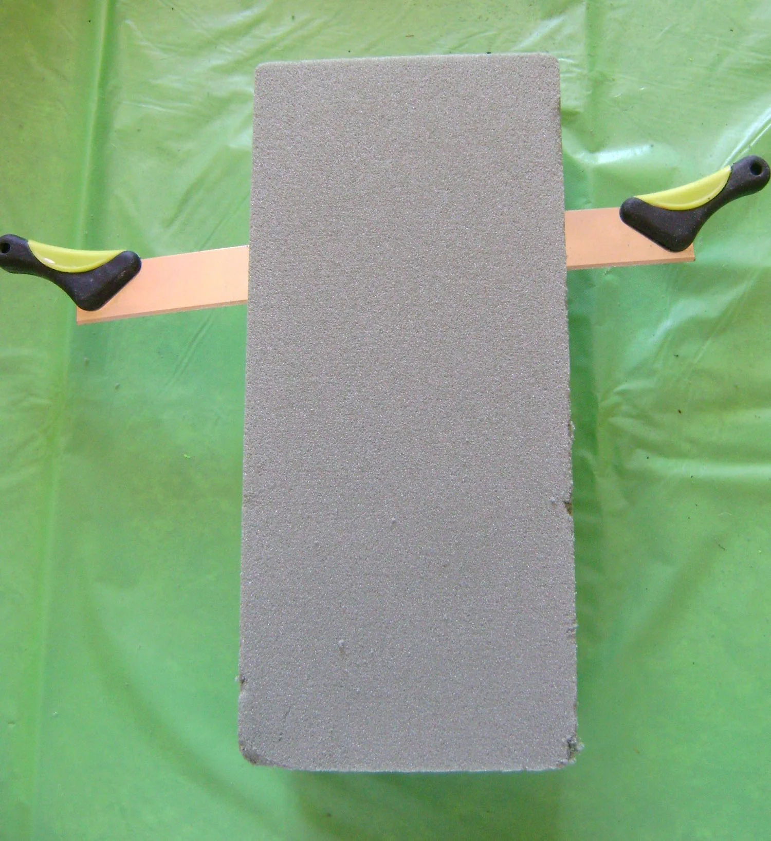 step 1 - Slice the floral block in half lengthwise. Shape it into a “V” to fit into the basket. Glue pieces of floral block together to fill the space. Remove the block and press orange gift wrap tissue to the inside. Replace the block.