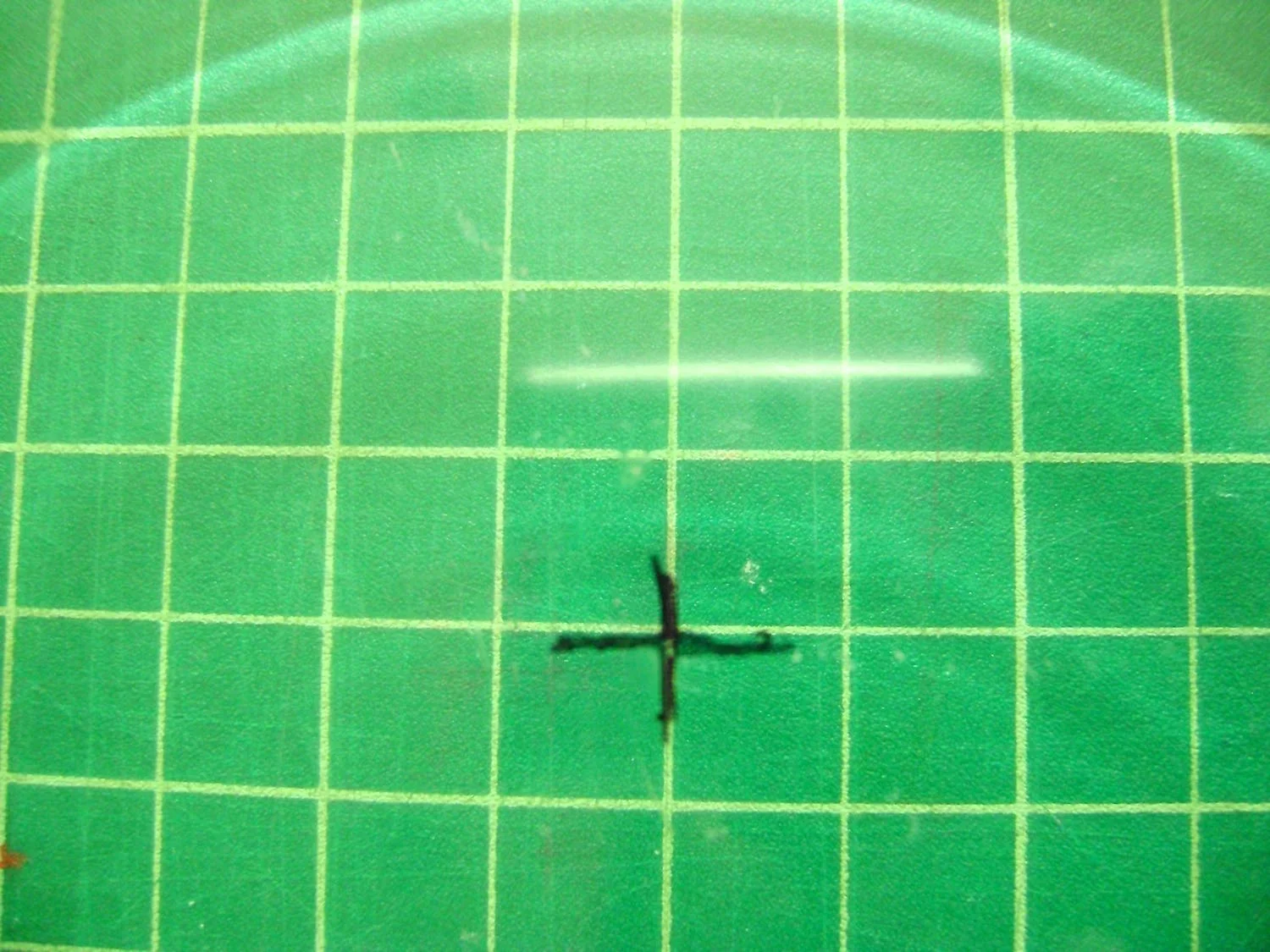 step 2 - Place the glass plate on a cutting mat and use the grid to measure the vertical and horizontal center of the glass. With a Sharpie pen mark the inside of the plate.