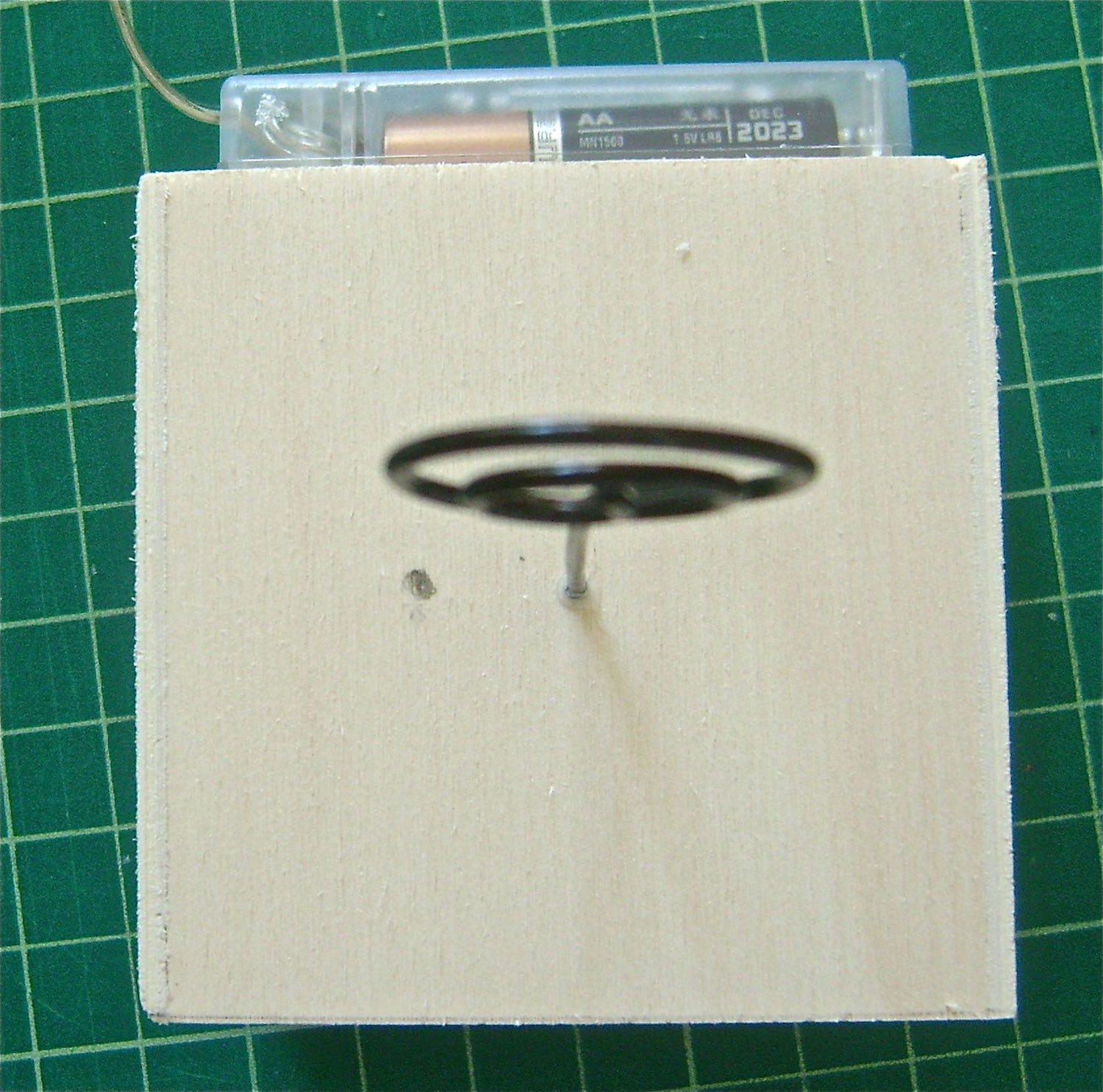 step 2 -Make another mark about .50” to the left of the wire photo holder in the top of the cube. Drill holes in the two marks large enough to pass the light string through.