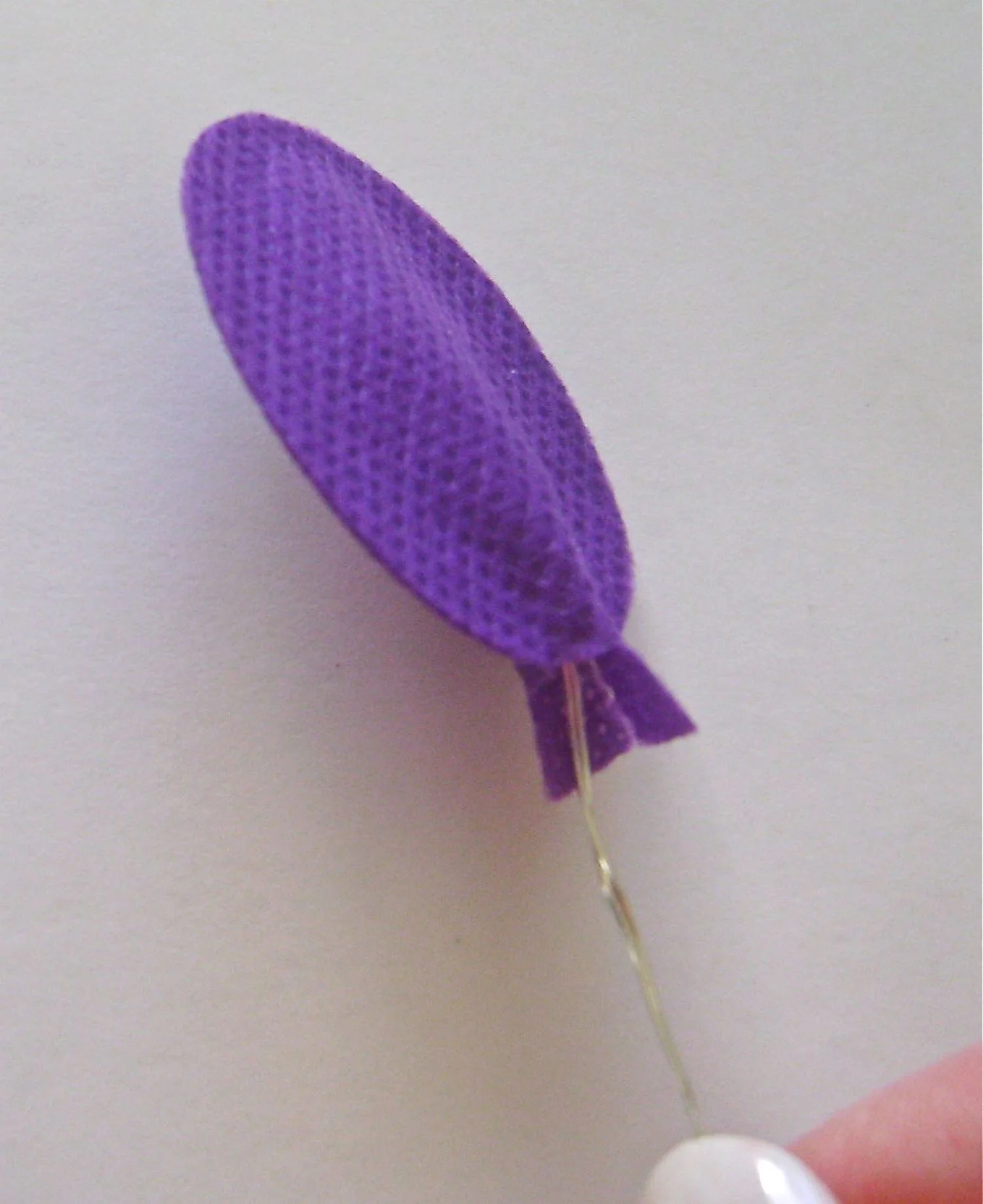 step 9 - Gather the 18 bulbs on the light string into six groups of three. Bend each into a small package to fit inside the fabric balloons. Hot glue the balloon center bottoms to prevent the wires from pulling out. Push a floral stem into the hole in the top of the cube. Slip the other end into a balloon and bend it to support the light string and other balloons.