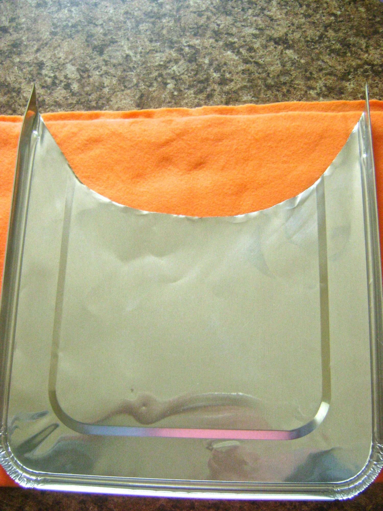 step 1 - The Metal Basket Use scissors to cut the foil pan cover in half with a curved edge. The cut foil will be sharp so handle the it with oven mitts. Lay the cover front side on a towel, fleece or other soft, thick material.