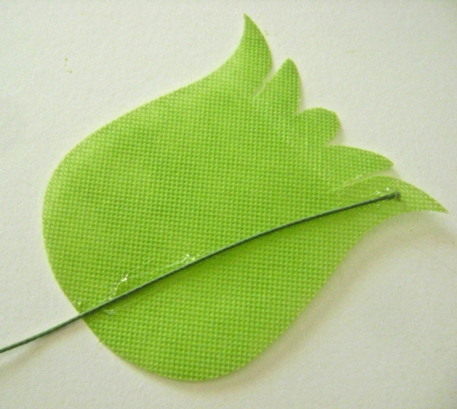 step 11 - To assemble the tulips, place a line of hot glue extending from the bottom center of the back tulip to the top right edge. Lay a floral wire on the glue line. Floral wire will allow you to position the tulips in several ways. Apply glue to the top and side perimeters of the petal. Press the back petal to the front aligning all edges. 