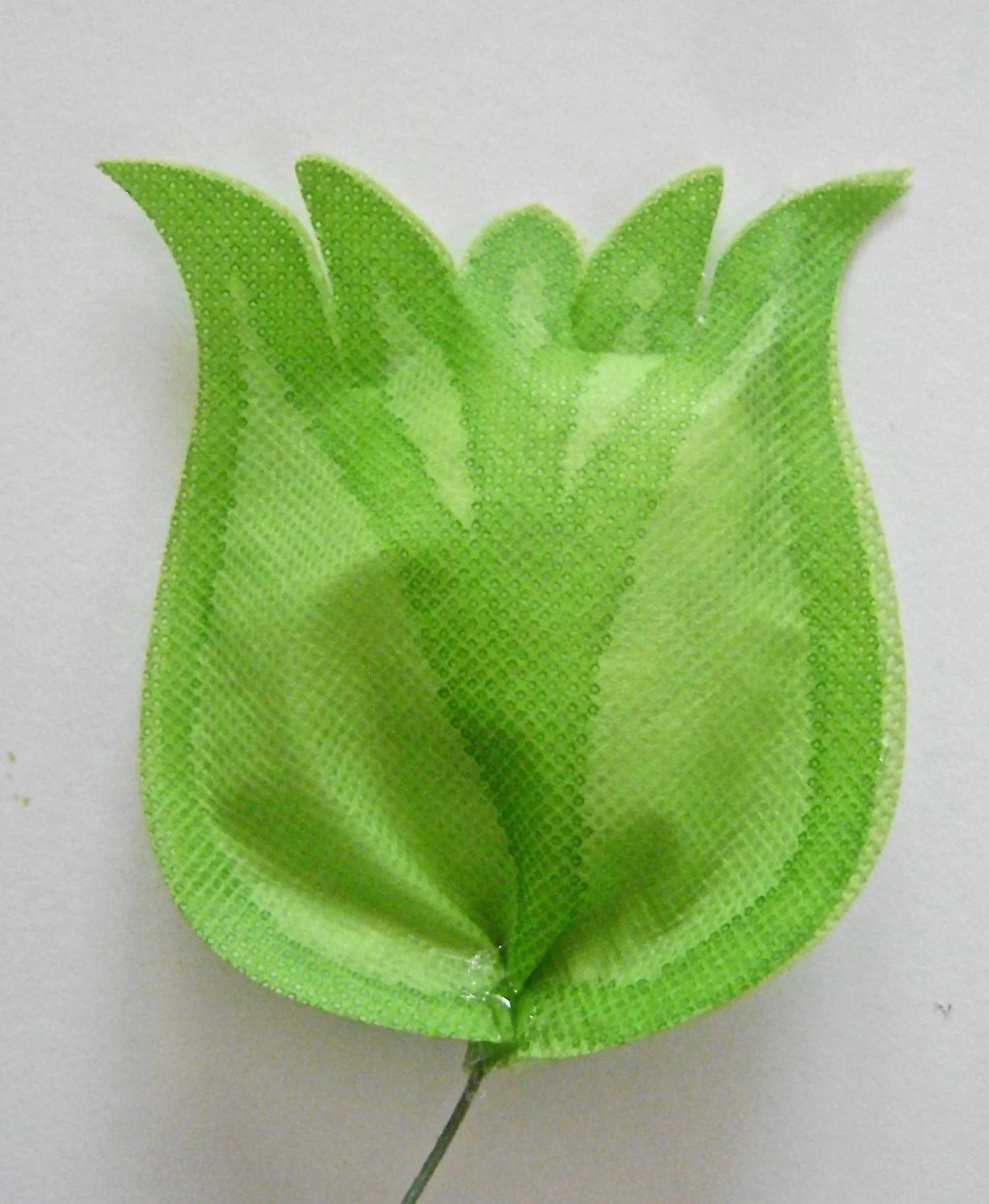 step 12 - Stuff white plastic shopping bag pieces into the tulip opening. Any printing on the bags will be visible through the fabric so cut them away before stuffing the tulips. Hot glue the bottom open edges of the tulip. Create a small pinch in the bottom of the tulip for dimension and hot glue it together.