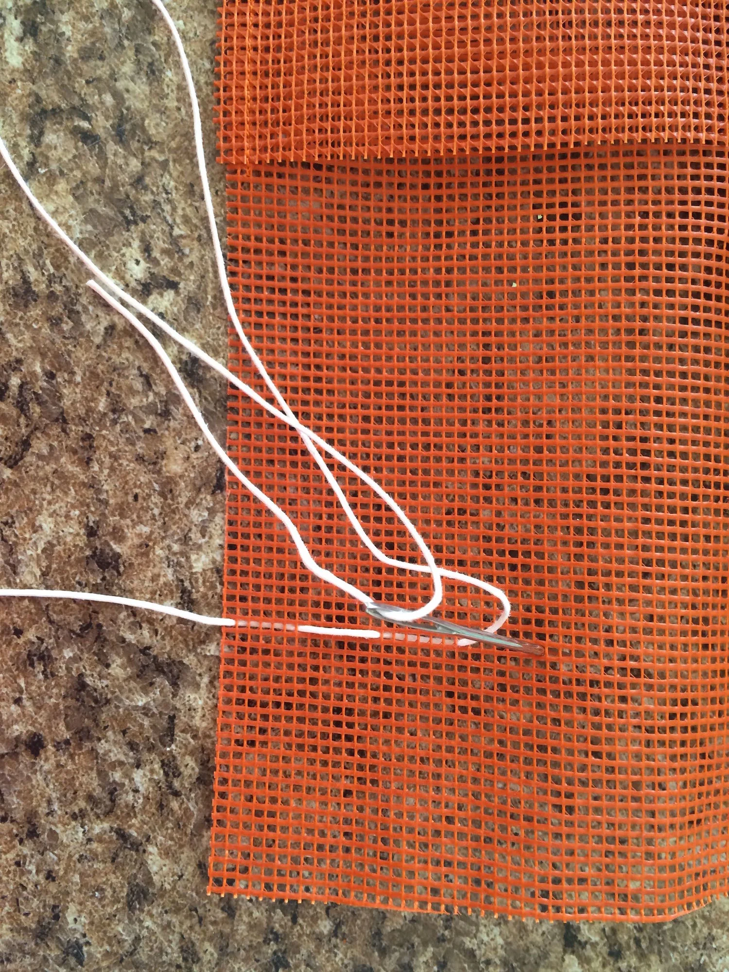 step 5 - Measure your tallest tool and mark that many inches from the bottom with a pin. Thread a large darning needle with 24” of cotton cord and weave it in and out of the mesh every half inch across the length of the mesh.