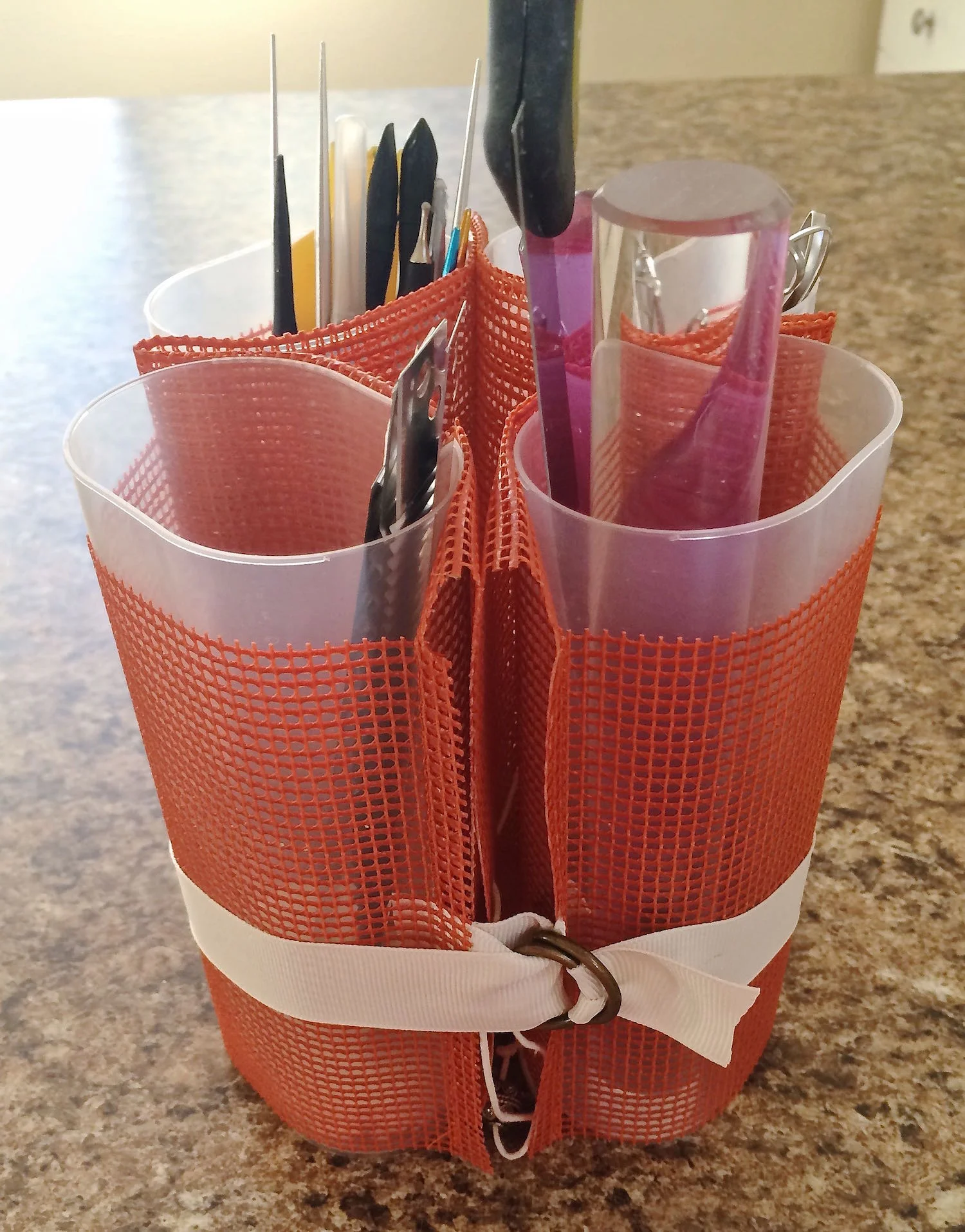 step 9 - To group the containers, wrap the ribbon around them then secure the end in the “D” rings.