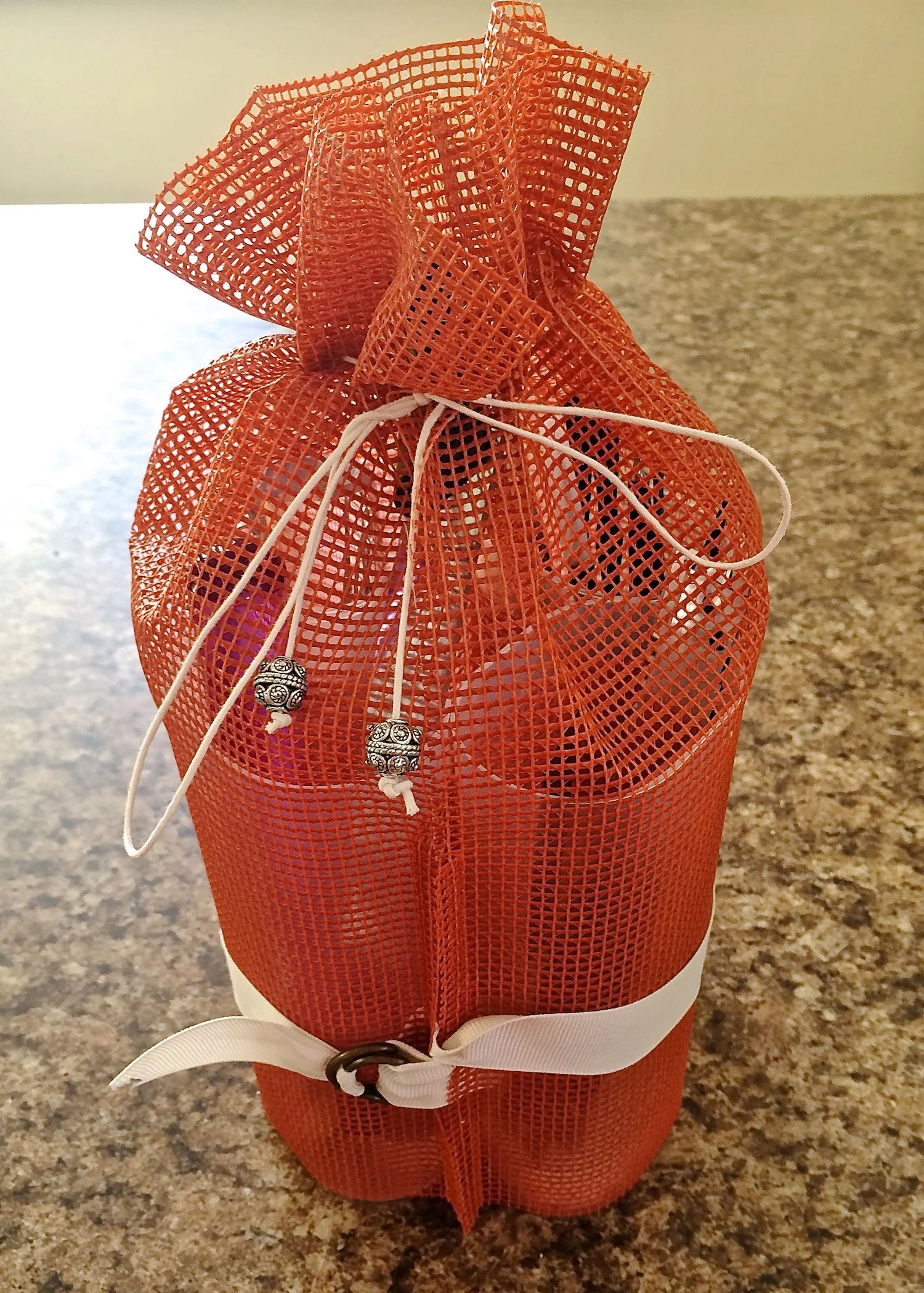 step 10 - Prepare the package for travel by flipping up the fabric back (cuff). Turn the containers in toward each other and secure them with the ribbon. Pull on the drawstrings and tie the ends together.
