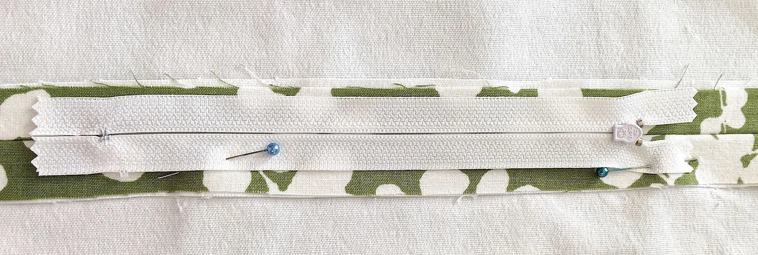 step 10 - Pin the zipper right side down onto the opening. Sew the zipper to the fabric.