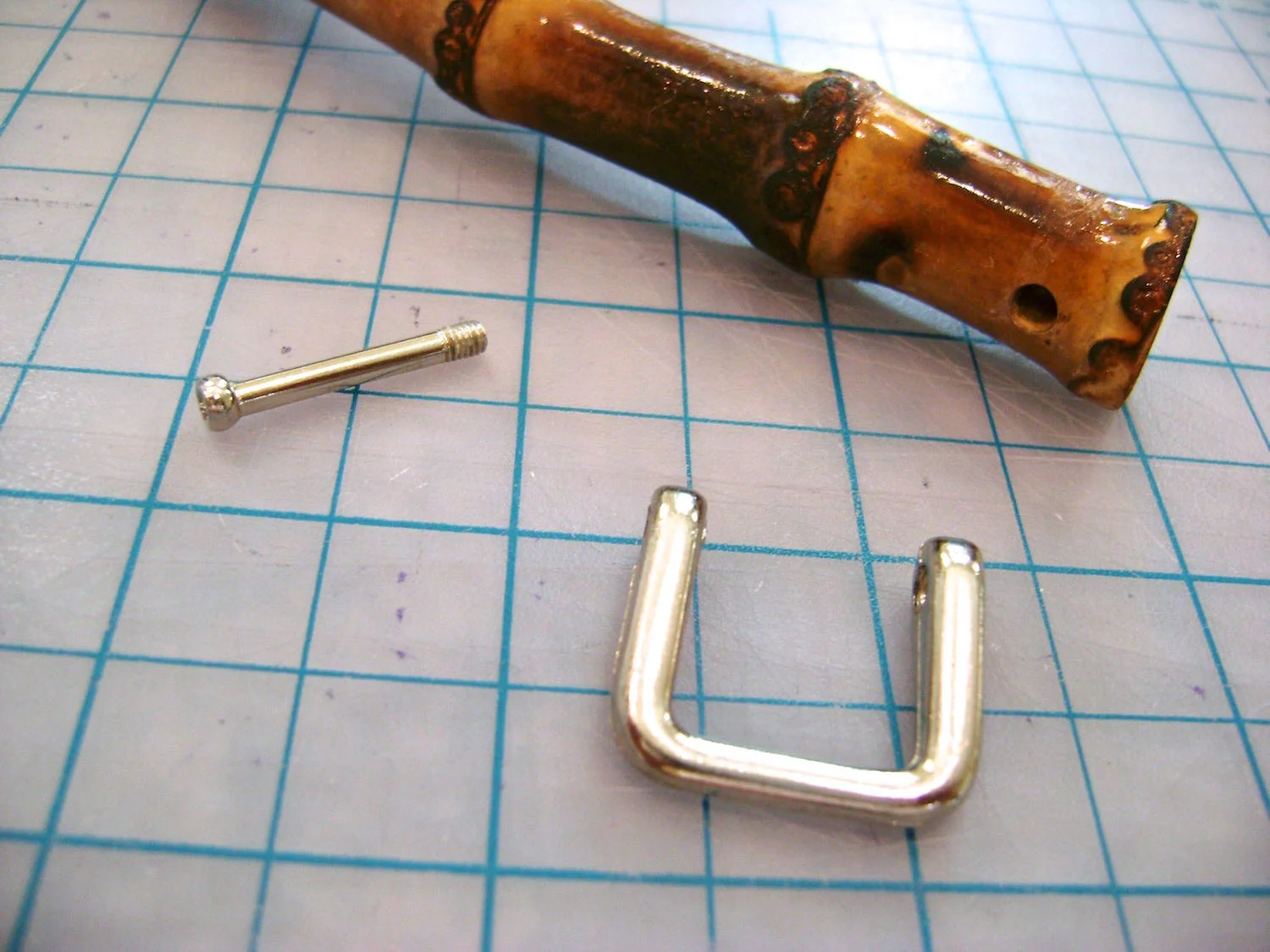 step 10 - Remove the screws in the bamboo handles and thread the metal “U” into the purse loops.