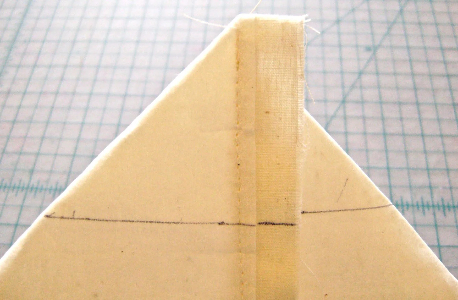 step 7 - Make a line against the ruler with a pen or tape. Flip the layers over and mark the other side. Machine stitch across the ruled lines.