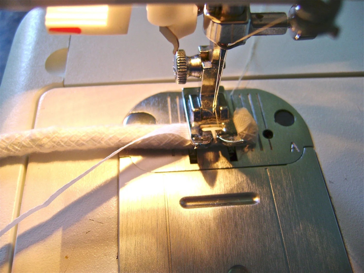step 1 - Once your casings are made, an easy way to insert the piping is to sew ribbon or seam binding to one end of the piping. Attach a safety pin to the opposite end of the ribbon. Lead the pin through the casing and pull the piping through.