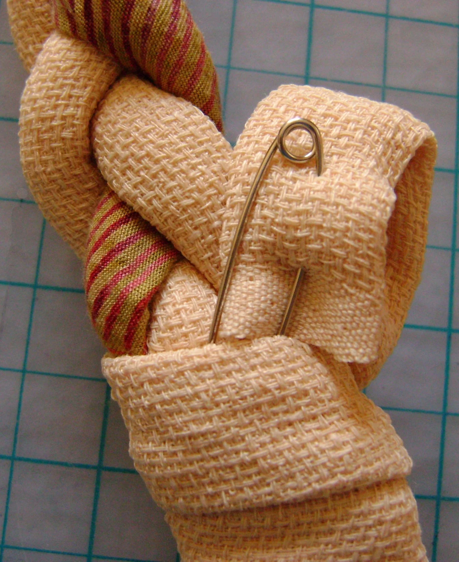 step 5 - Attach a safety pin to the tail end of the wrap. Lead the pin through the top of the wrap.