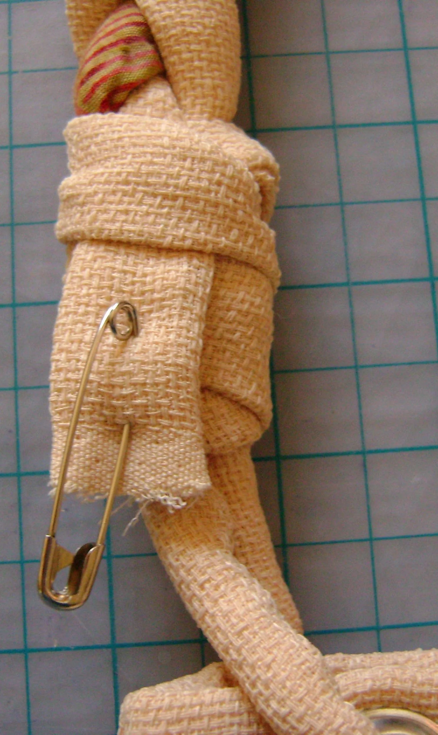 step 6 - Pull through the first band of the wrap. Cut off enough of the tail so it will be hidden under the band.