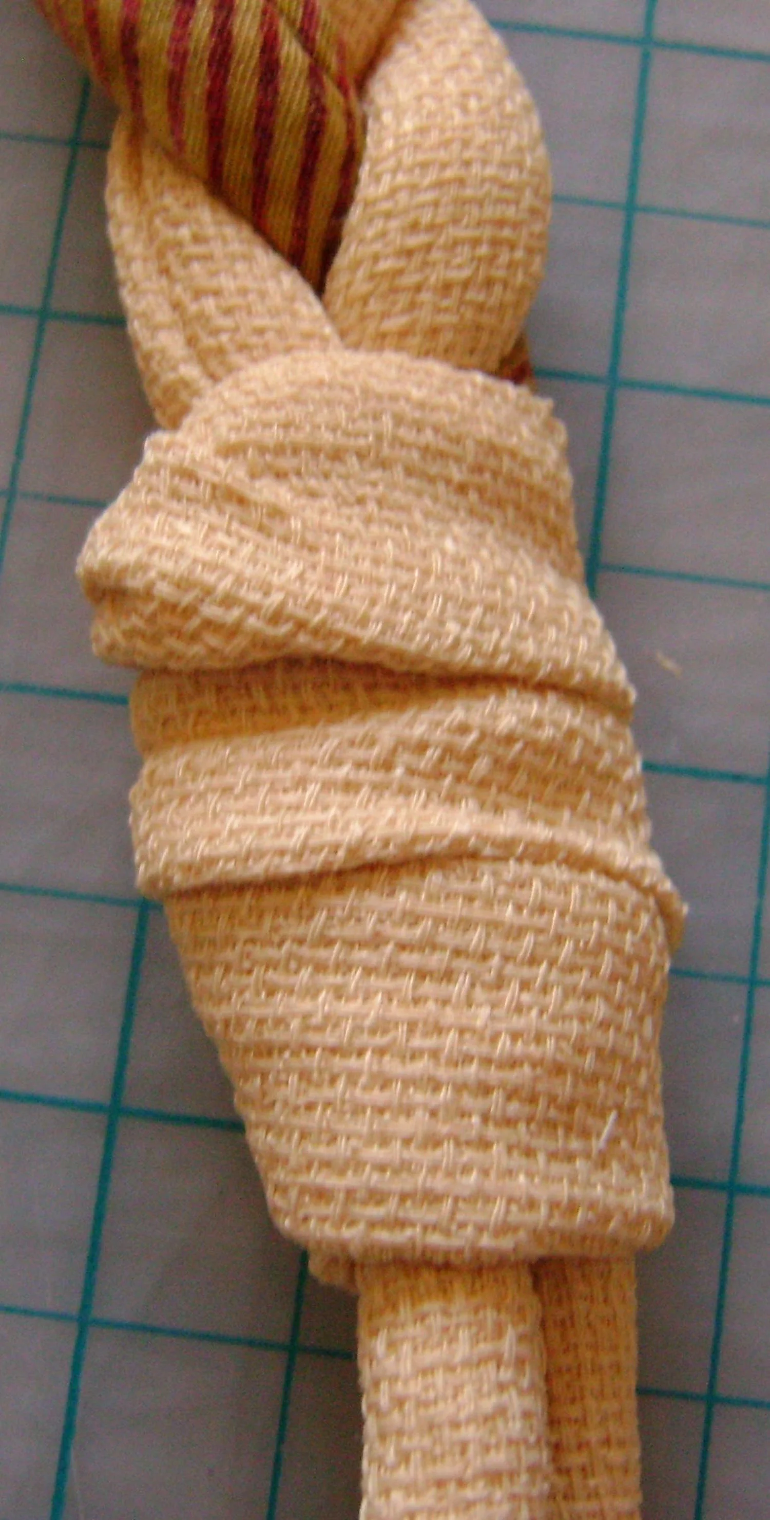 step 7 - Hand stitch under the band to hold the tail securely in place.