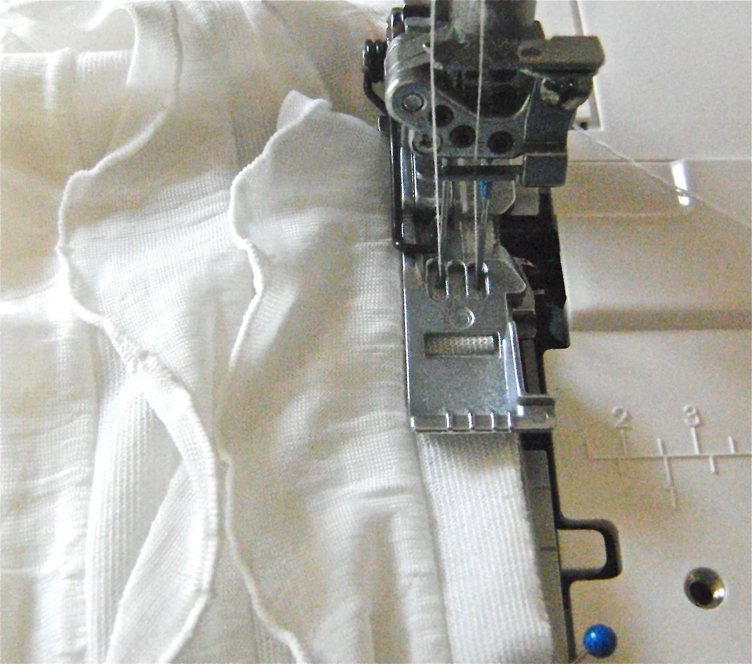 step 6 - Stitching ½” from the raw edge, sew through the ruffle margin, shirt fabric, and stay tape, beginning at the shoulder and ending at the slit in the “V”. Finish the 3 joined edges with a zigzag or overlock stitch.