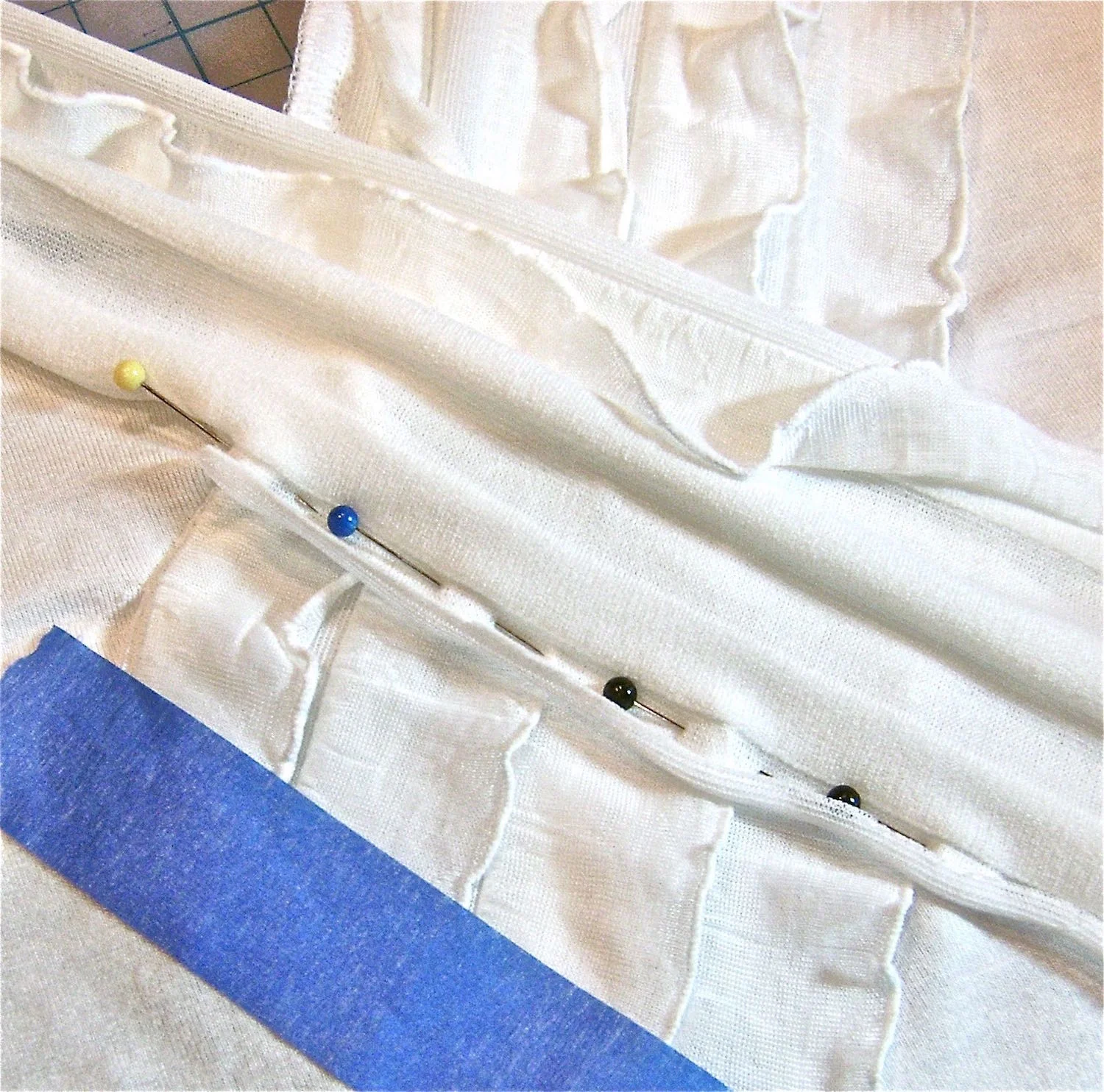 step 10 - With the right side of ruffles to the right side of the shirt, sew the remainder of the left ruffle strip to the shirt, from the slit, over the left ruffles and all the way to the hemline. Remove the tape on the left ruffle strip and trim excess.