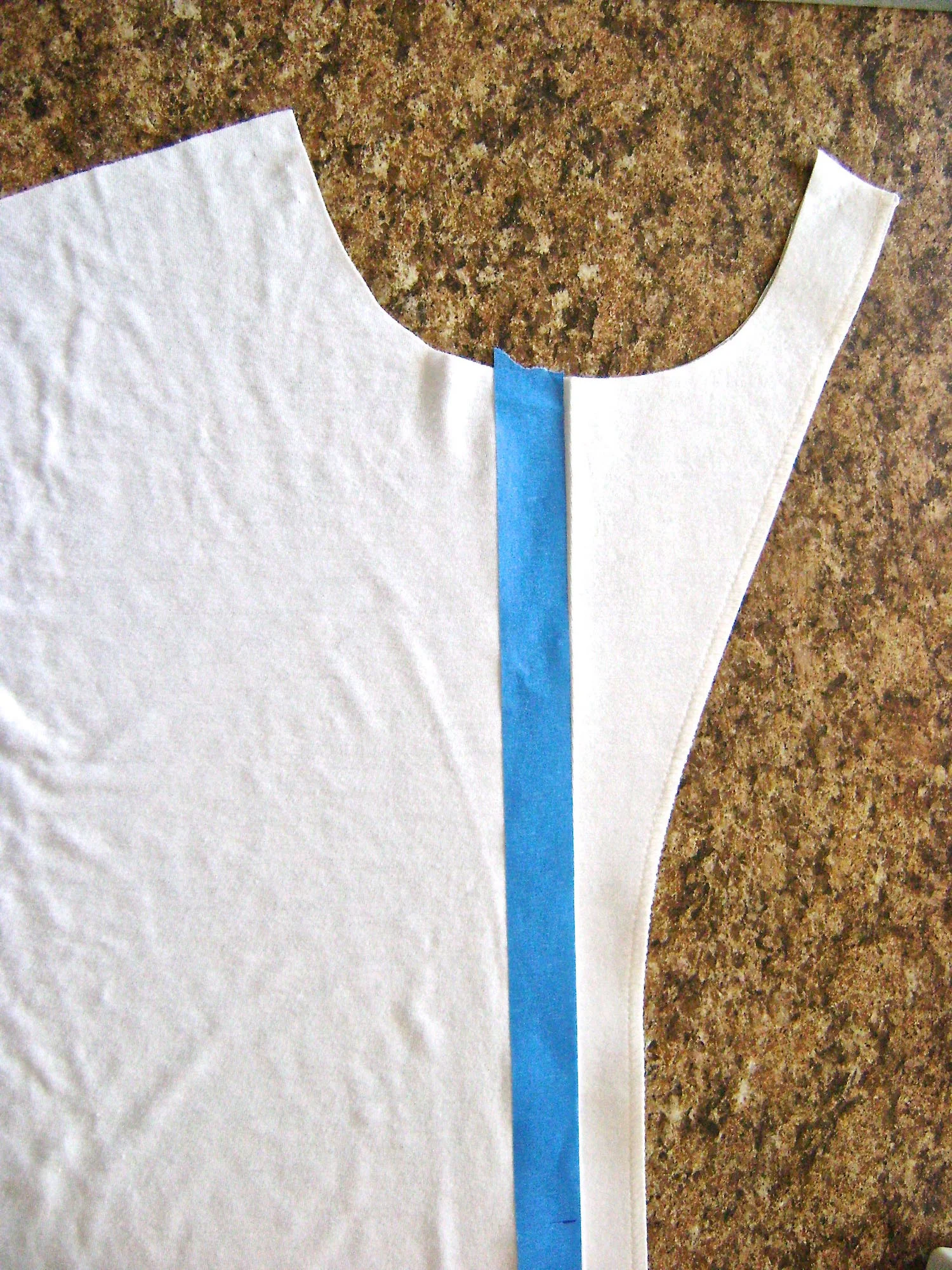step 4 - Place one-inch wide painters tape down the front of the left side knit fabric piece. The left edge of the tape should align with the fold line for the facing.