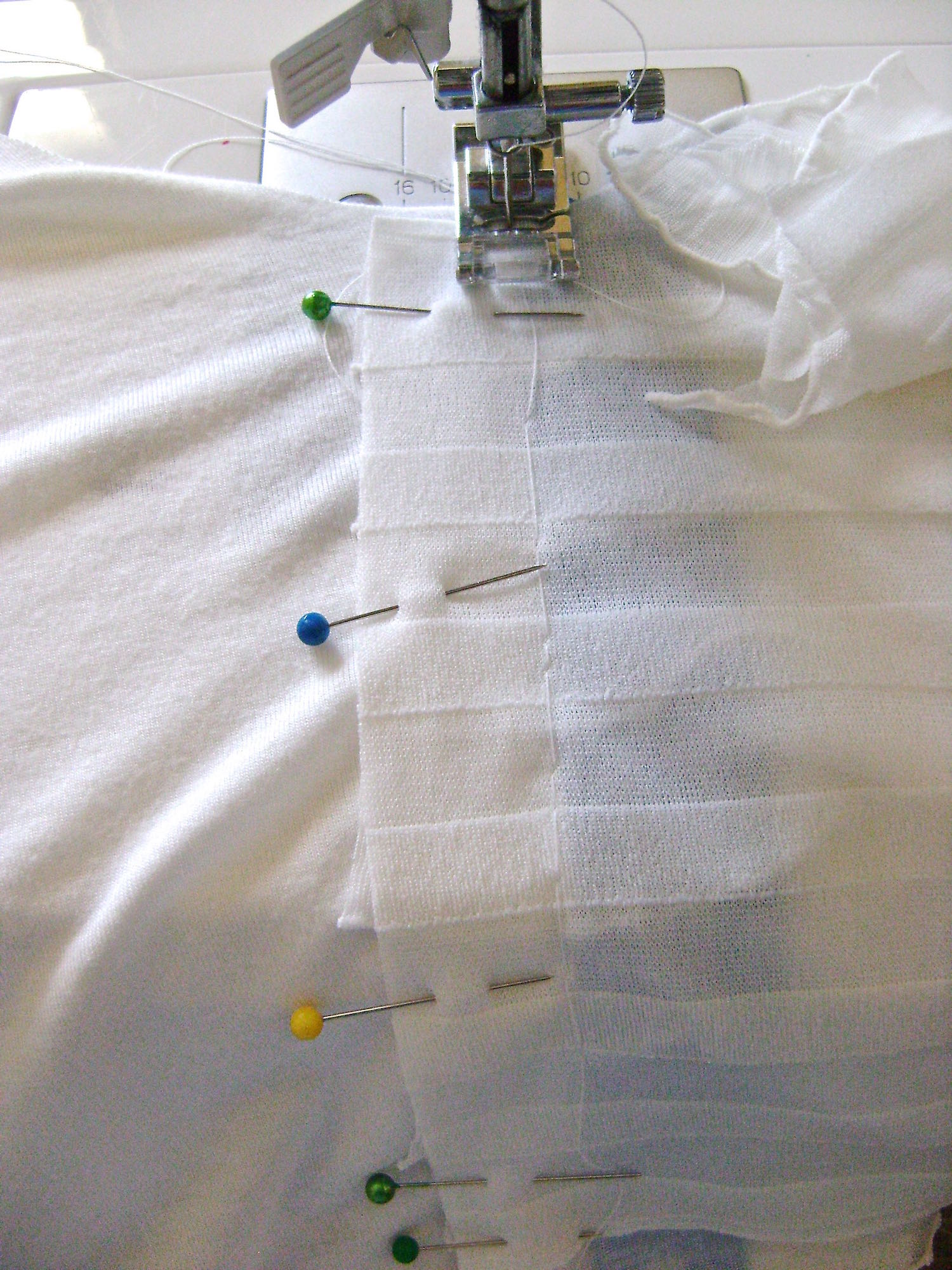 step 5 - Pin or baste the left ruffle piece in place, aligned one-inch away from the right edge of the tape with right sides together. Sew in place and trim away 3/4” of the ruffle allowance.