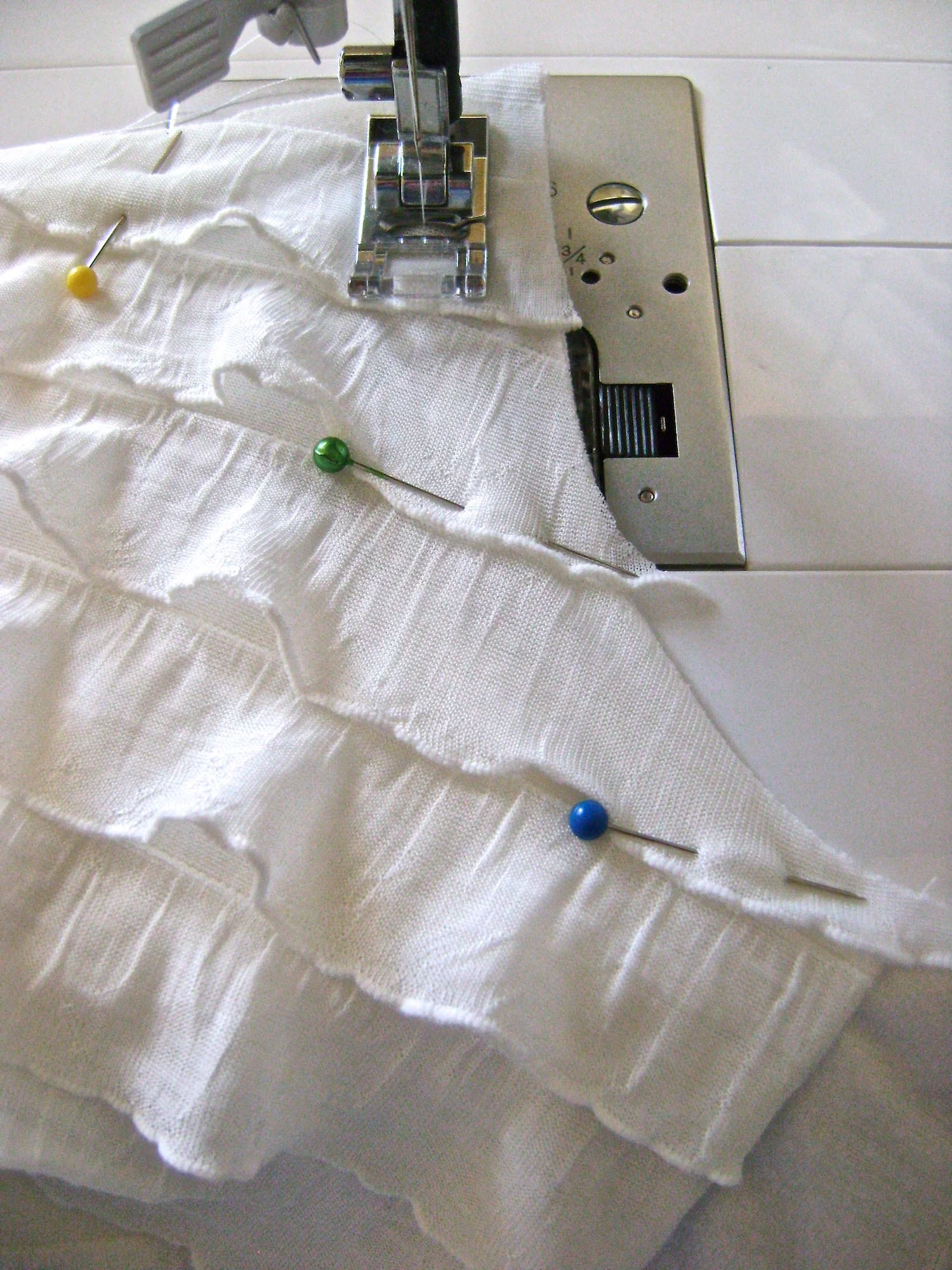 step 7 -Pin the knit fabric and ruffled fabric together at the shoulder, neck, armhole and side seam edges. Sew together 1/2” from raw edges. 