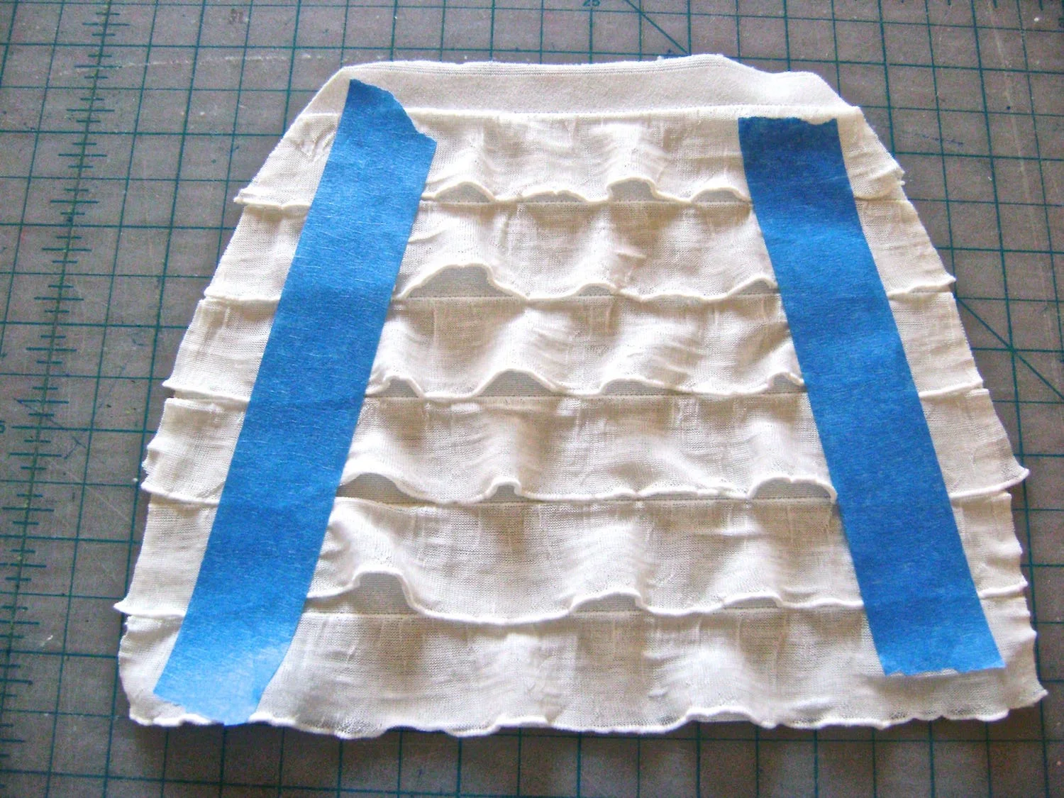 step 1 - Download and print the purse pattern. Use it to cut out two ruffled pieces, two fleece pieces, and two satin lining pieces. Taping the ruffles down will prevent them from shifting while you cut. The bottom edge of a ruffle row should align with the bottom edge of the pattern. 