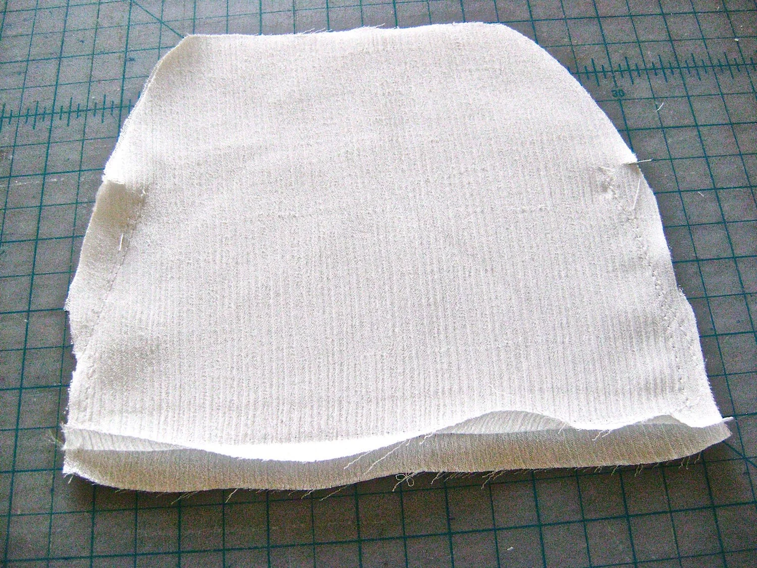 step 5 - Sew the center 5” of the lining bottom seam with a basting stitch. Press the seam open. With a normal stitch, sew the bottom seam 1” in from both corners. Sew the side seams with 1/4” allowance from the bottom to the side opening notches. Remove the bottom basting stitch and set the lining aside. If you will be attaching a personal label to the lining, this is a good time to do it.