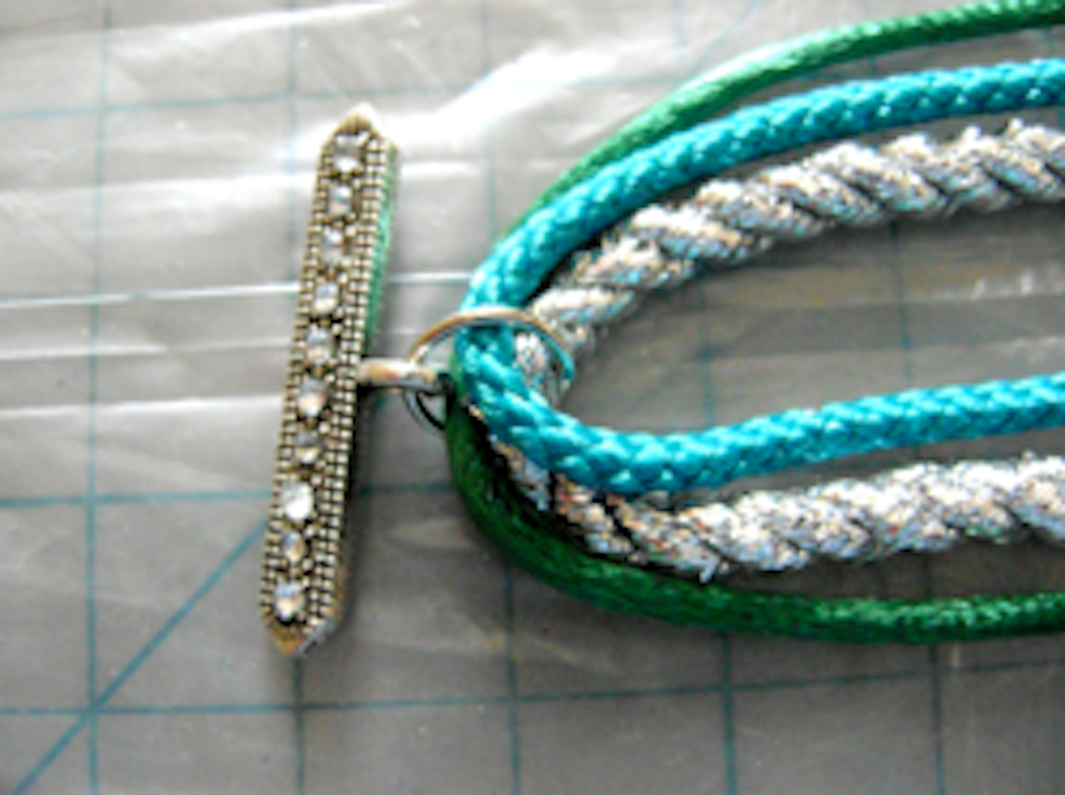 step 2 - Use pliers to attach a jump ring and clasp to the folds. 