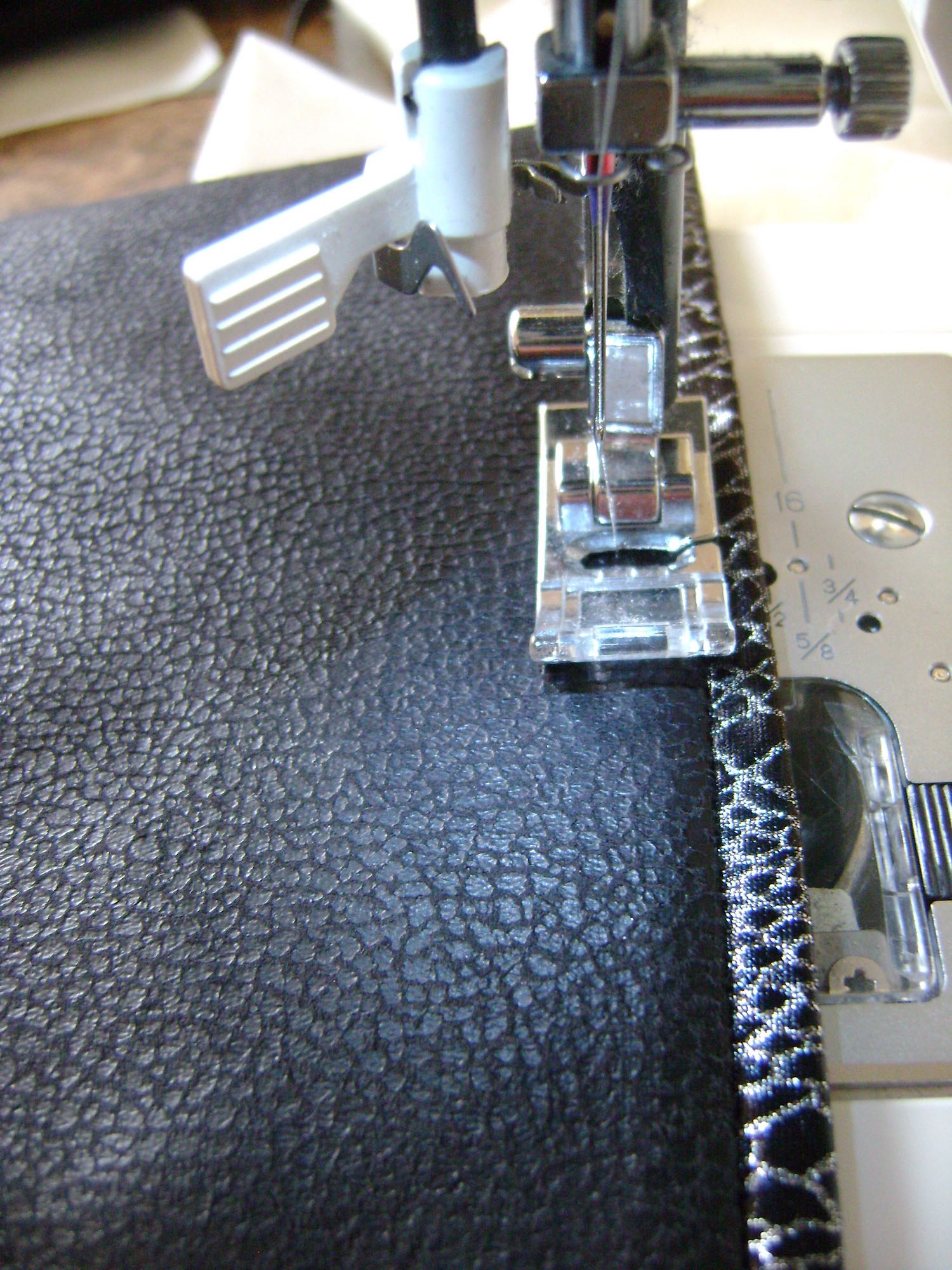 step 10 - Use a feather stitch (found on most zigzag machines) and silver metallic thread to top stitch across the pocket edge. 