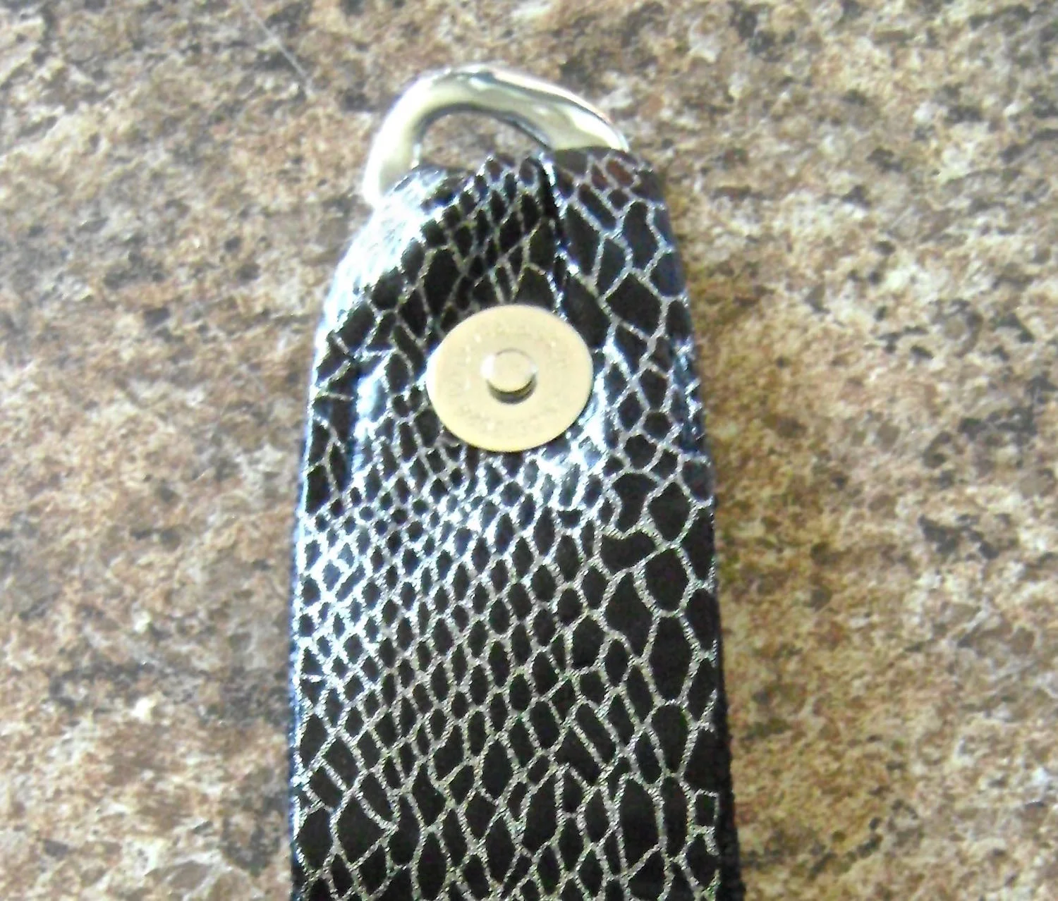 step 24 - Fold the purse snap flap in half with right sides together. Trim seam and turn right side out. Pass one end through one chain link and pin the raw ends together. Attach a magnetic snap to one flap layer. Stitch the layers together close to the edges and to within 1.5” of the link.