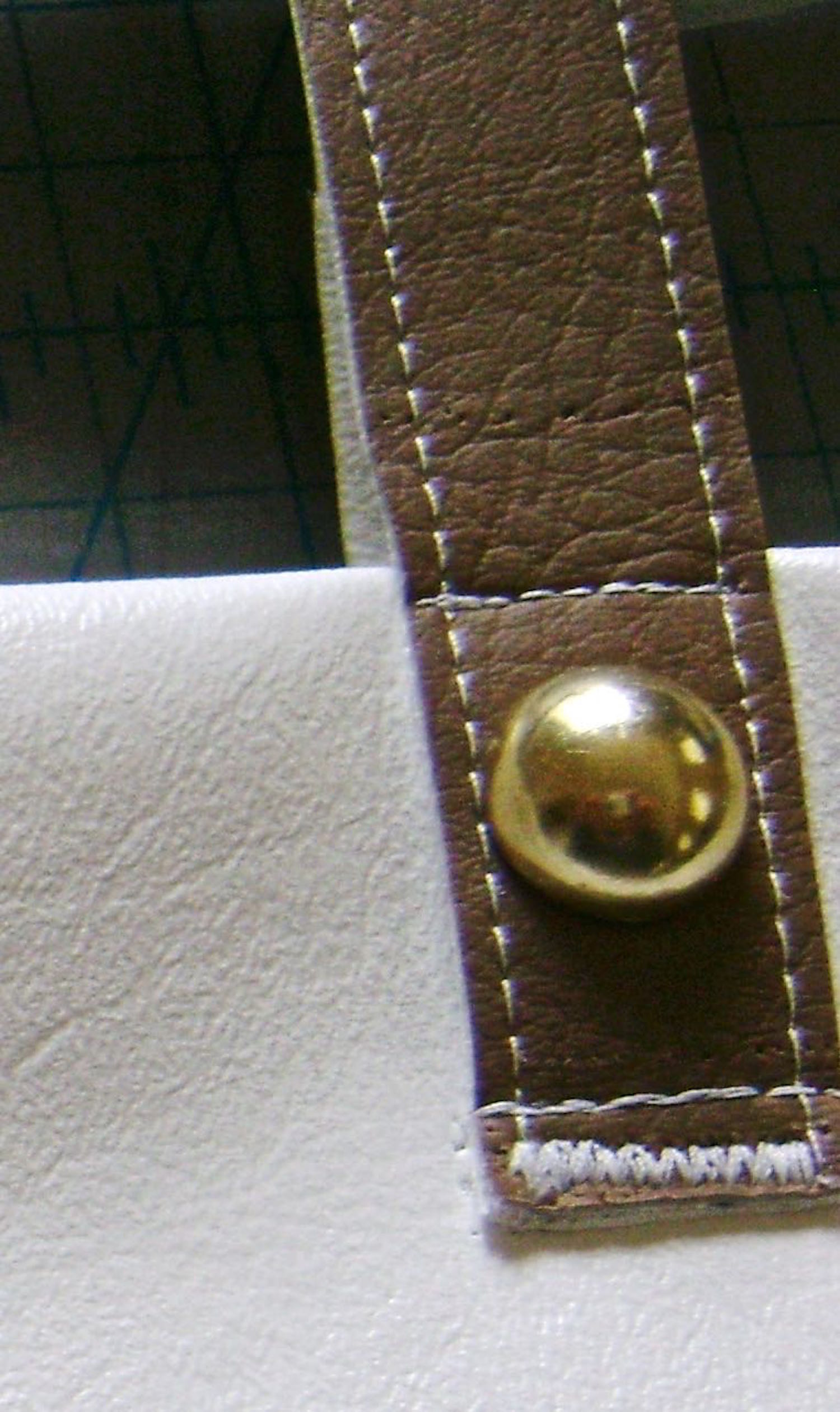 step 19 - Attach the straps 2” from the bag’s side seams and and 1.75” from top edge. Zigzag with a narrow stitch close to the strap edge and topstitch .25” above that. Attach a stud to the strap then topstitch the strap to the very top edge of the bag.