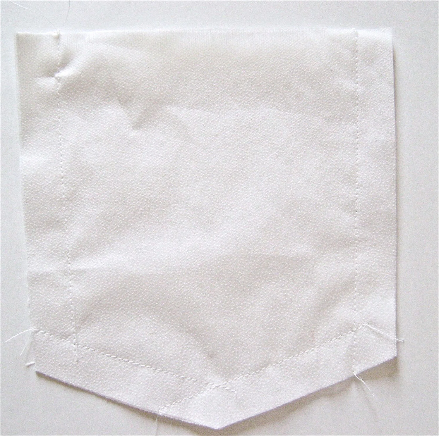 step 2 - With the right sides together, sew the fabric to the interfacing. Angle the stitch inward from the top of the pocket to the crease line then continue sewing to the bottom edge. To sew the bottom seams, don’t turn the fabric at the center to make one line of stitching. Instead sew lines from the outer edges to the center. Stitch a line across the points where the seams intersect (center bottom).
