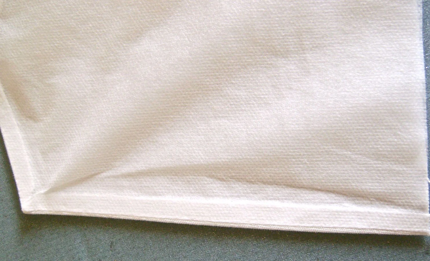 step 4 - Turn the pocket right side out pushing out the corner points. With an iron, press all the outside edges except across the pocket top, to fuse the interfacing to the fabric. Avoid making folds in the interfacing as you press.