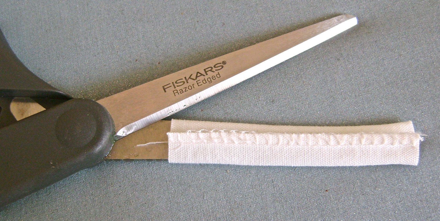 step 13 - 5 Easy Belt Loops Fold a strip of fabric 1.50” wide by 15” long in half with wrong sides together. Serge the edges with a .50” seam. Cut five 3” long pieces from the strip. Slip each piece over the blade of your scissors and press with an iron to create creases along the outside edges.