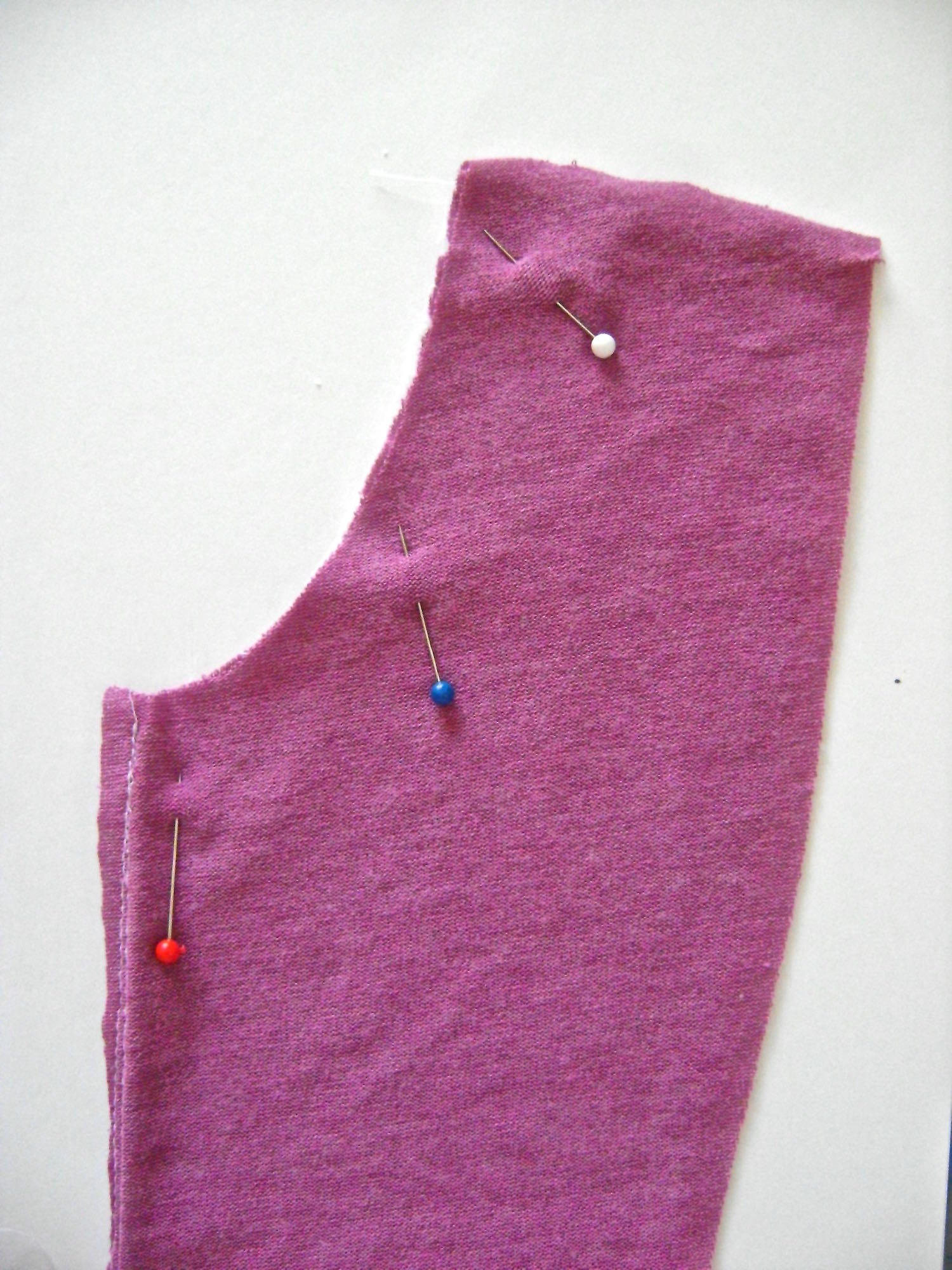 step 9 - Pin the right sides of the fabric together and sew the neckline seams. Trim the allowance and top stitch it to the facing fabric.