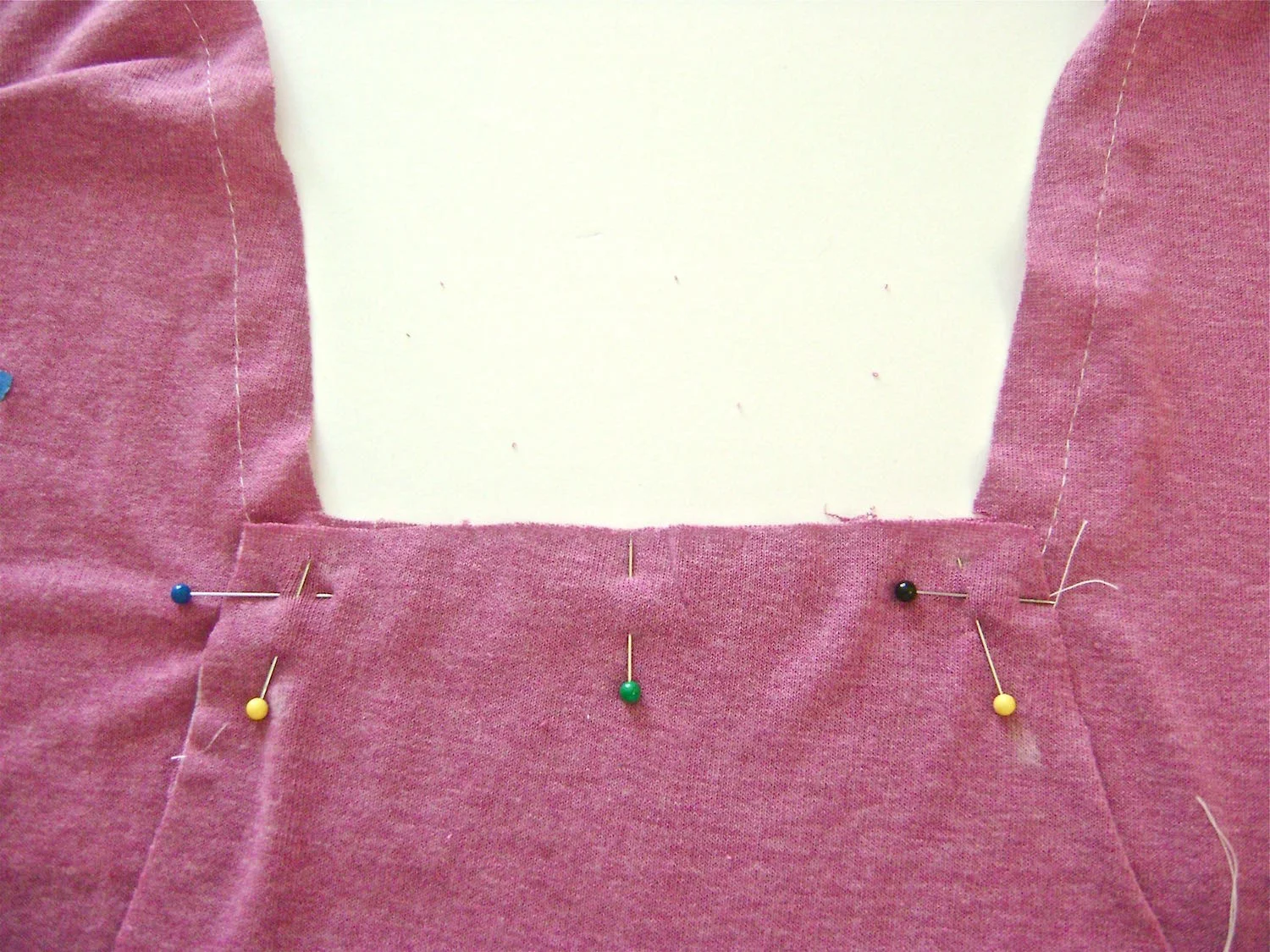 step 13 - Pin the bottom of the placket to the shirt front with right sides together. Sew a horizontal 5/8” seam from corner to corner. Pin each placket side to the fabric and sew with right sides together.