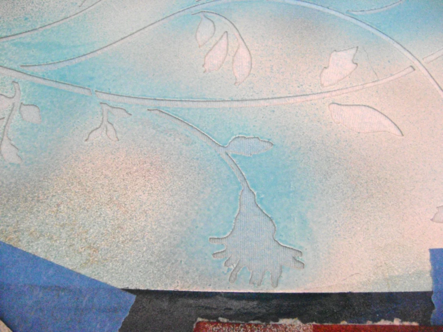 step 6 - Airbrush color onto the stencil alternating blue and green paint. Begin with the blue first spraying only some areas. Finish by painting the remaining areas green and blending the green into the blue edges.