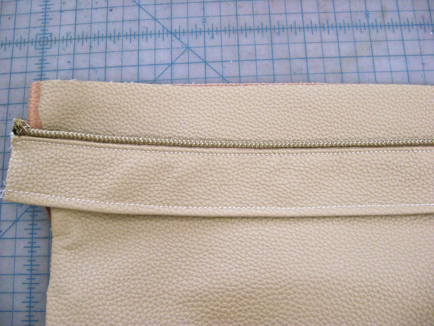 step 14 - Using a zipper foot, sew a 16" piece of piping to one edge of the luggage band with right sides together. Stitch the lining right side down over the piping. Sew the other side of the band and lining together using stay tape. Turn the wrong sides together and topstitch .25 from the edges.