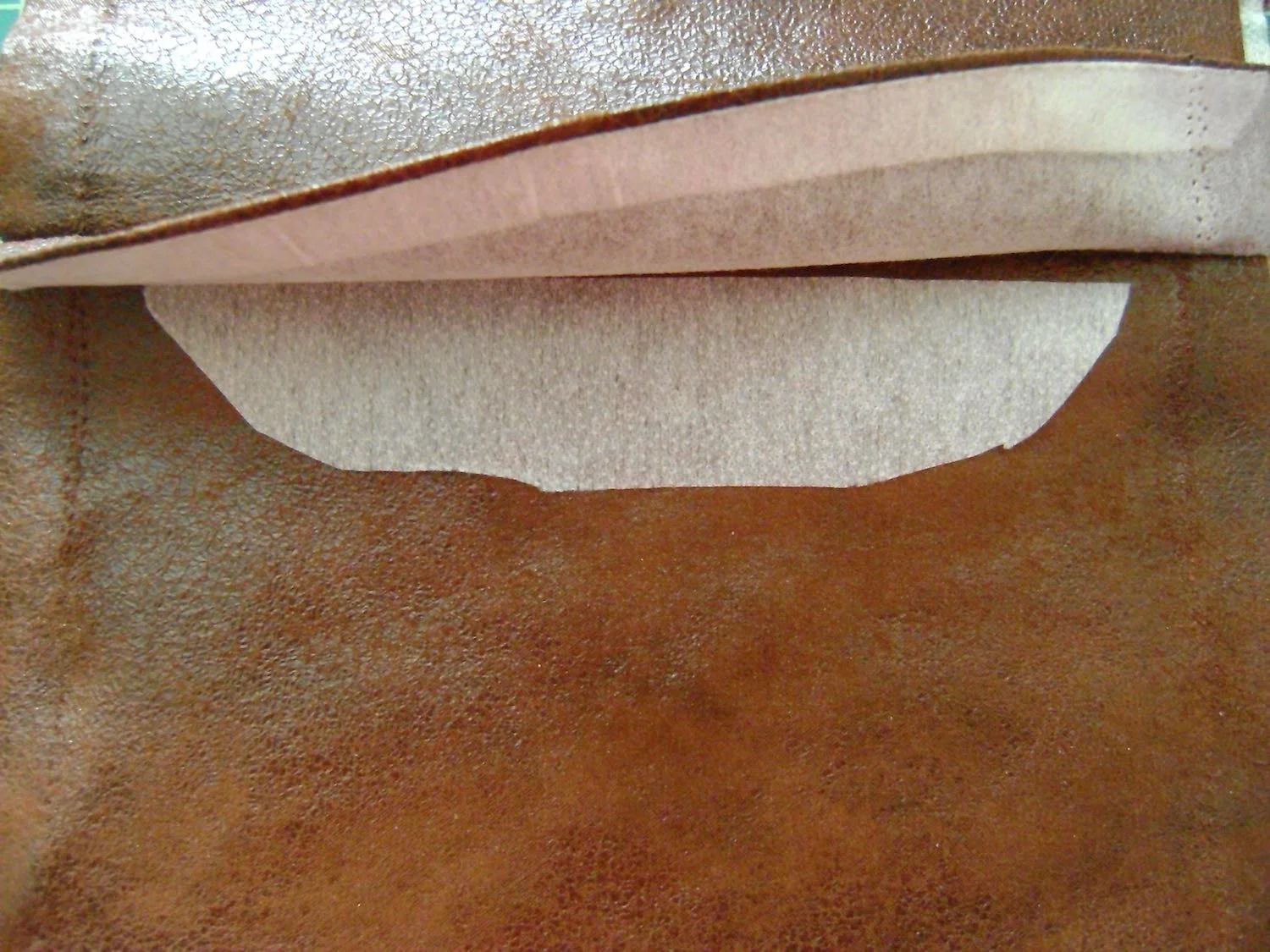 step 4 - Baste the straight edge of the feather cover to the edge of the front matching notches, with wrong side of cover against right side of fabric. Cut out a piece of interfacing that will fit under the cover.