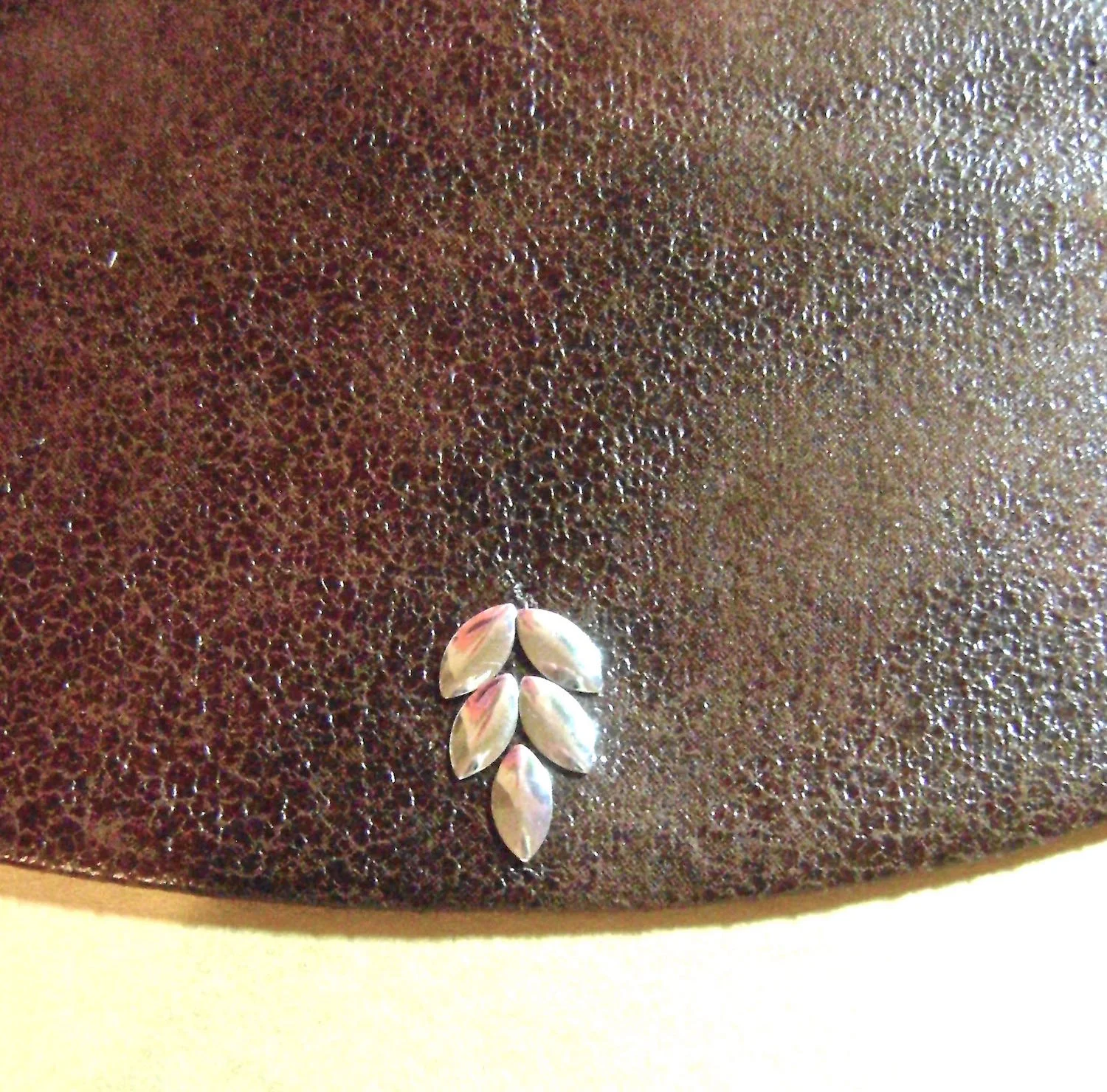 step 11 - Position 5 nail head pieces within the pins. Remove the pins. Cover the nail heads with a cloth and hold an iron on them for about 45 seconds.
