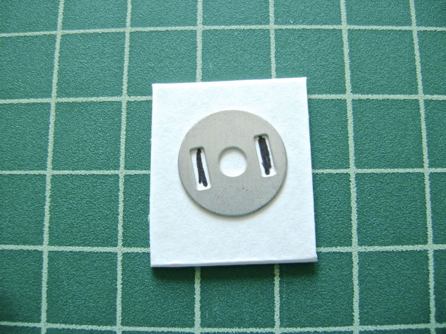 step 20 - Cut a piece of stiff cardboard a little larger than the size of the clasp. Mark and slit the prong openings. Adding this cardboard when you apply the clasp isn’t absolutely necessary but I like how the strength of the cardboard supports the clasp.