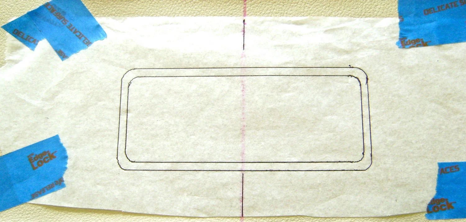 step 8 - Place a tissue pattern on the right side of the front vinyl piece aligning the center lines and positioning the stitch line of the pattern 1.75” from the top edge of the vinyl. Tape the tissue borders to the vinyl with painters tape.
