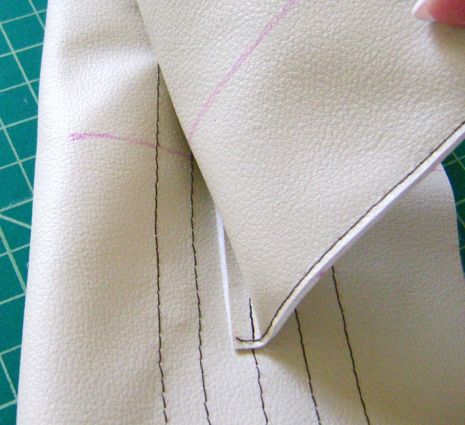 step 8 - With the band open, (not folded in half) align the raw edge of the flap against the first line of stitching at the top inside of the band. The center of the flap should match the center of the band. Sew the flap to the third line of decorative stitching then trim the allowance. Turn the flap up and sew another line of stitching to secure it to the top line of the band. Trim the flap with a thin strip of brown vinyl if desired. 