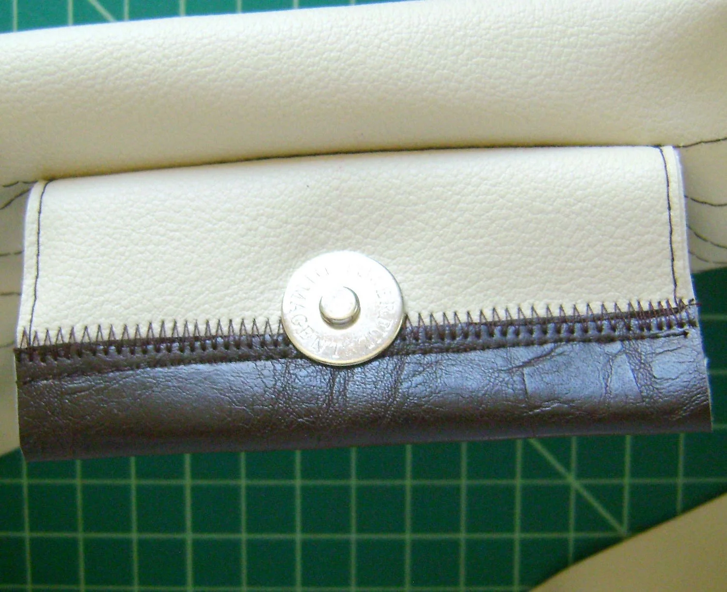 step 9 - Attach the magnetic clasp to the flap center. Attach the matching clasp piece to the opposite side of the band reinforcing it with a piece of cardboard on the back side of the band between the front and back clasp piece. Fold the band in half and pin the raw edges together.