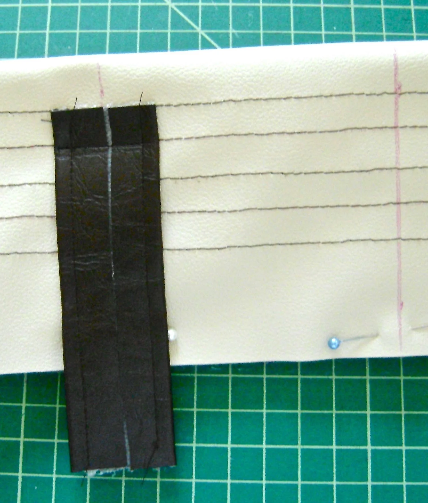 step 11 - Position each tab 4” from the center of the band. Sew the right side of a tab to the right side of the top band with the edge of the tab aligning with the first line of stitching. Sew over the second stitch line. Trim the tab close to the stitching. 
