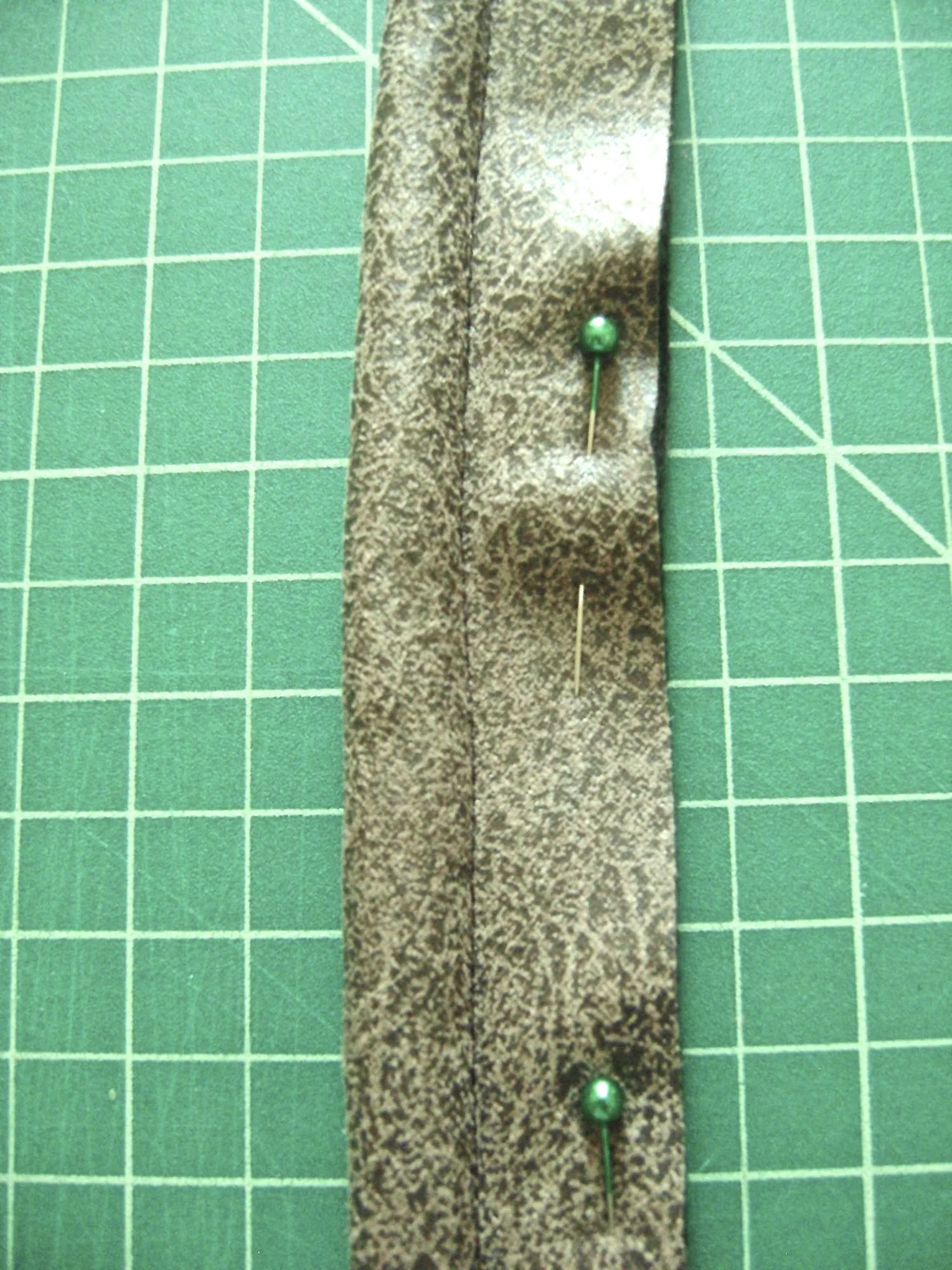step 26 - Straps and Loops Use a zipper foot to sew the vinyl with wrong sides together wrapped around piping. Trim close to the stitching.
