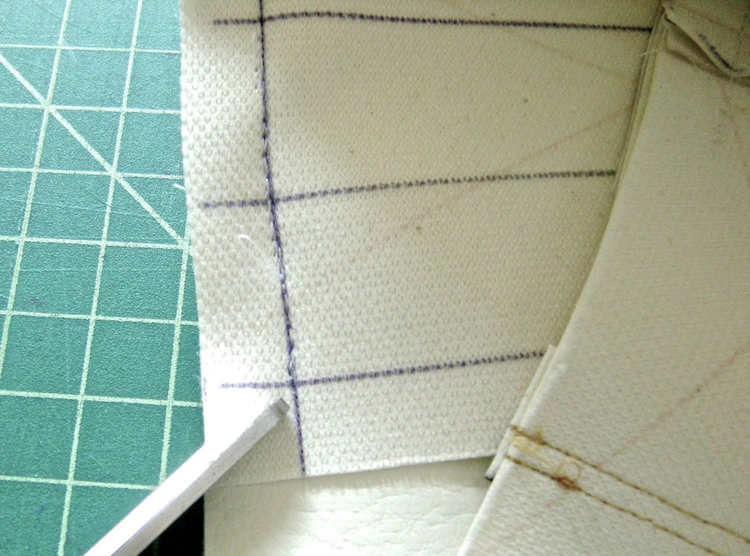 step 6 - Bottom On the wrong side of the center bottom piece, draw lines .50” from all edges and a line down the center. Make a small slit less than 1/2" on the front and back purse pieces 1" away from each side seam. Stitch the center purse bottom to the sides then the front and back with right sides together. Cut a diagonal slit in the corners of the bottom piece. Pivot the stitch at the slits to create clean, square corners. 
