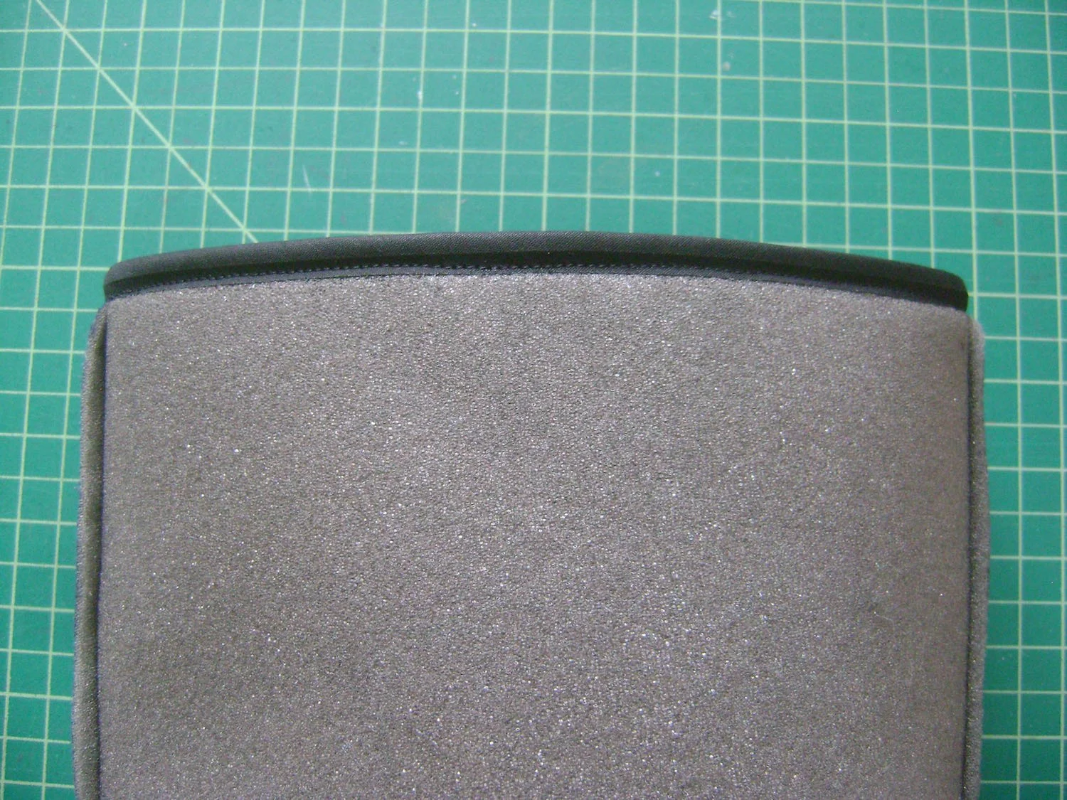 step 9 - Cut a piece of bias tape to measure 21". Sew the ends together. Encase the top edge of the headliner with bias tape by sewing one edge to the top of the headliner, then folding it over and top stitching the other edge.